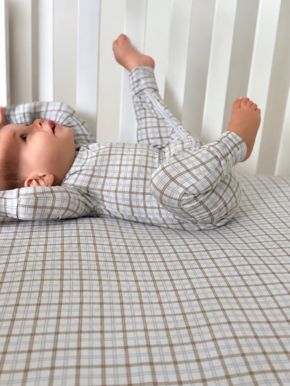 Plaid crib sheet with cream base and thin brown grid lines