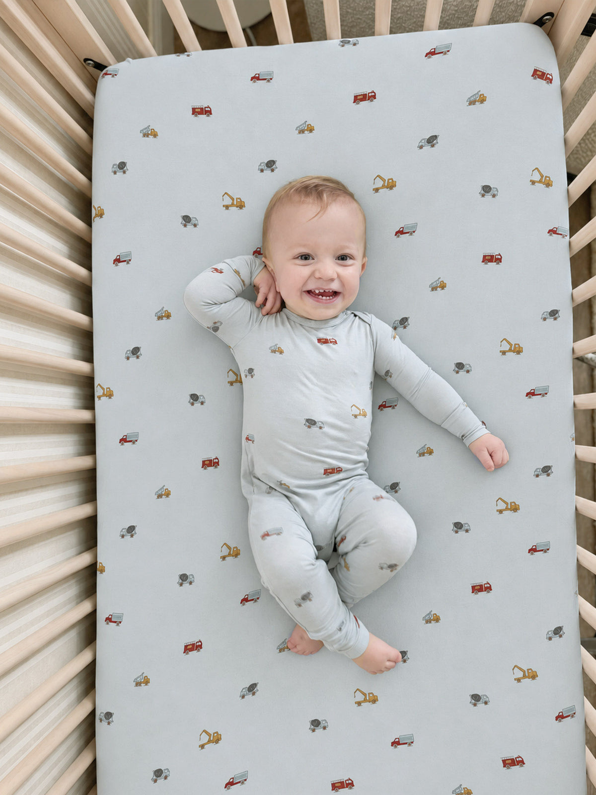 Light blue crib sheet with scattered car and wrench graphics
