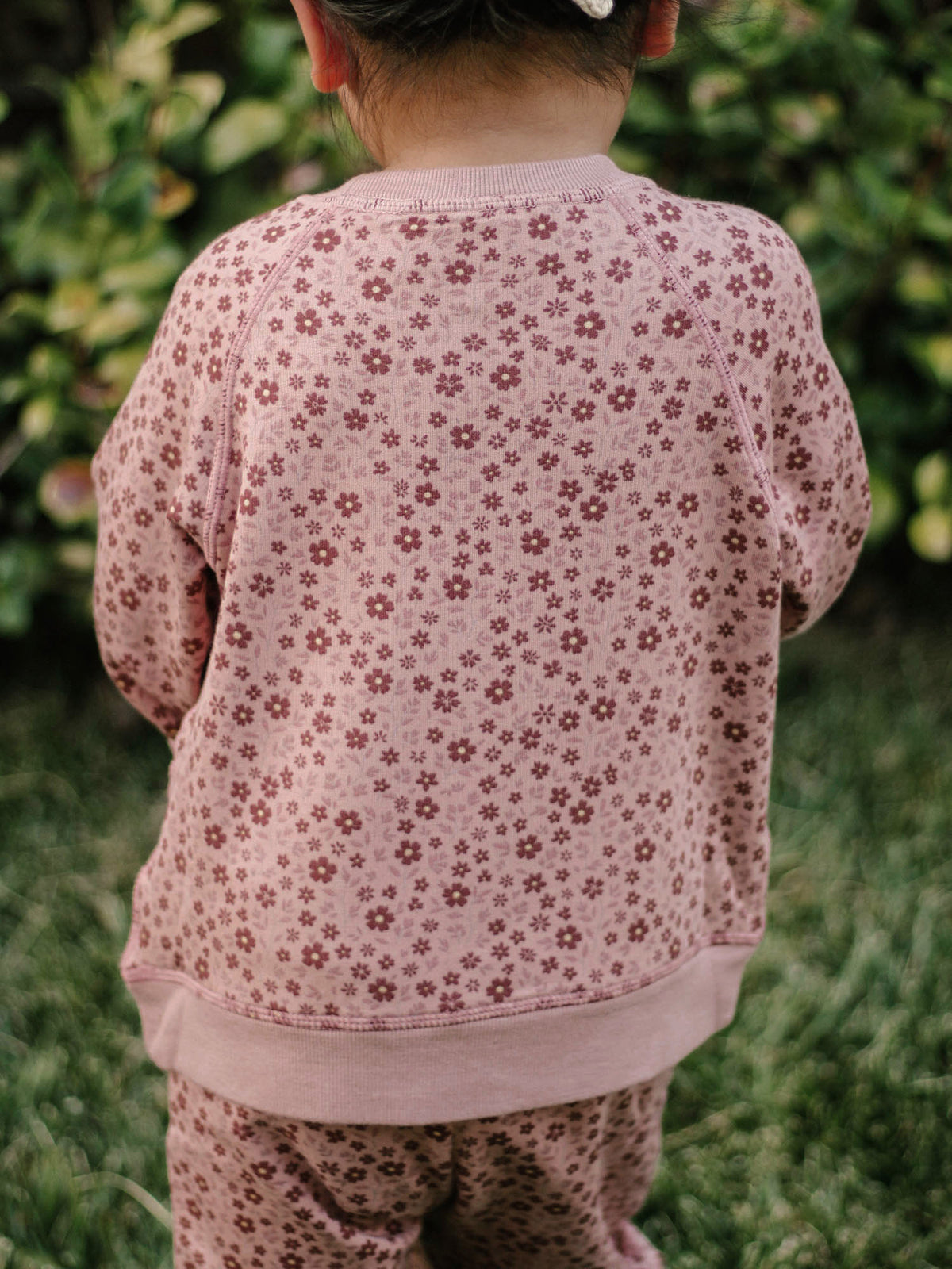 Pink fleece sweatsuit with petal floral print; sweatshirt and matching pants (back)