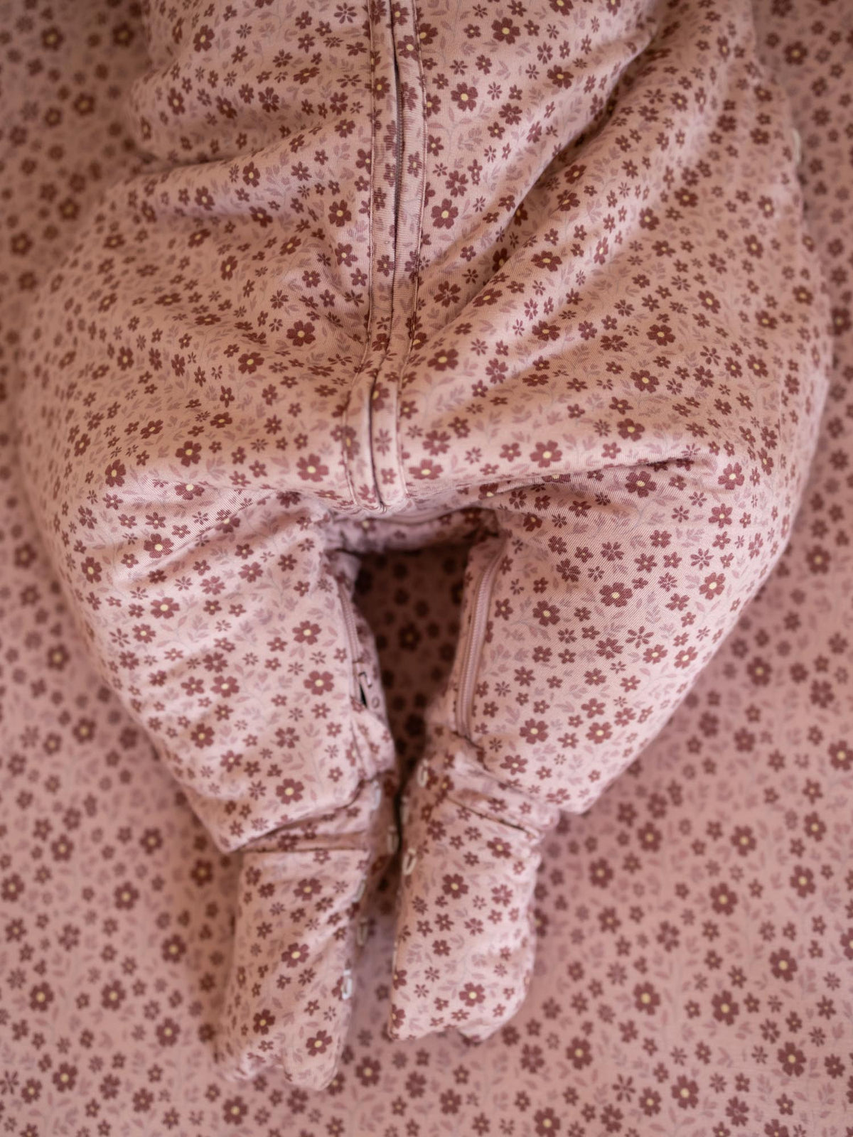 Blush pink floral footed sleep sack with front zipper and open ankle cuffs.