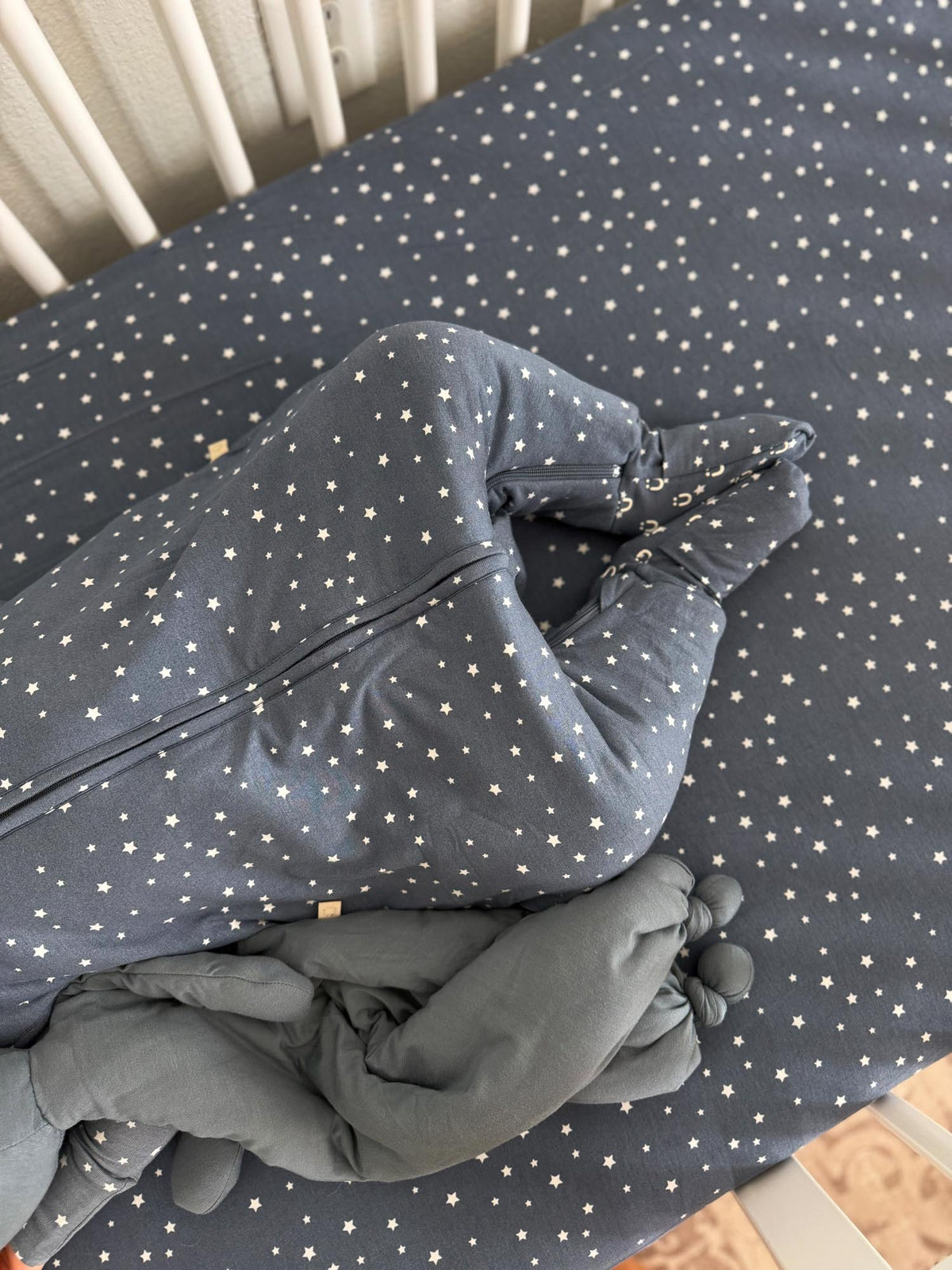 Folded gray star-print crib sheet with white dots