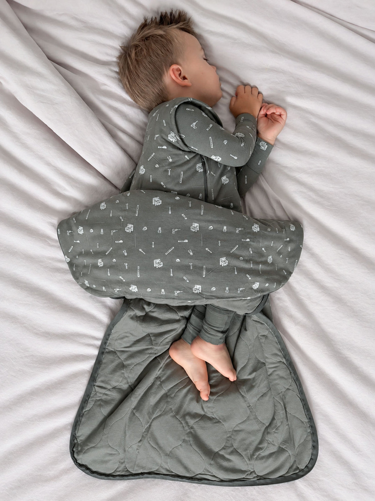 Dark gray sleep sack with white tool icons, zip front and padded wrap shape