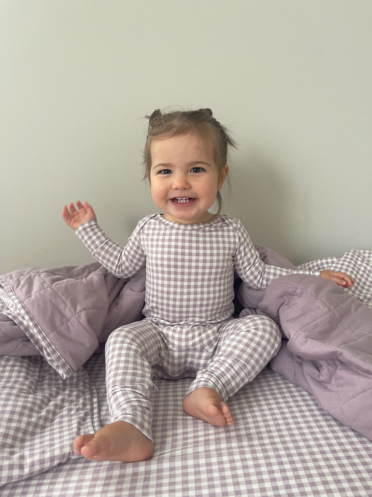 Gingham plaid baby pajama one-piece with long sleeves, cuffs visible