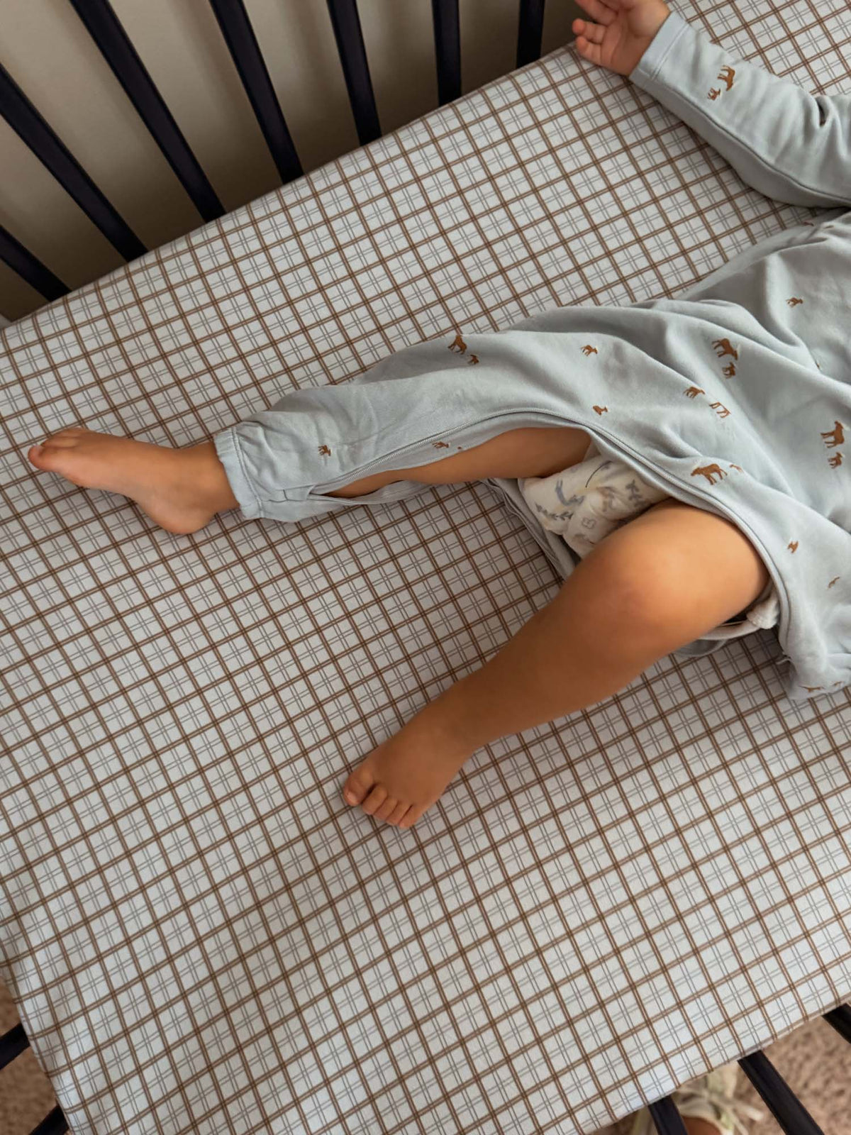 Light blue baby henley jumpsuit with long sleeves and moose print, lying down, partial view