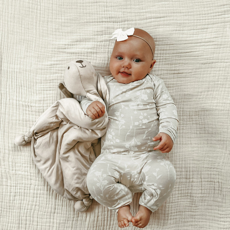 Plush bunny lovey attached to a soft beige comfort blanket, with stitched face