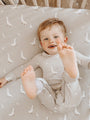 Light taupe fitted crib sheet covered in small white geese