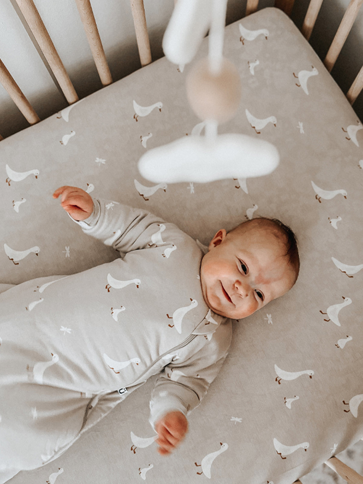 Taupe crib sheet with all-over white goose pattern