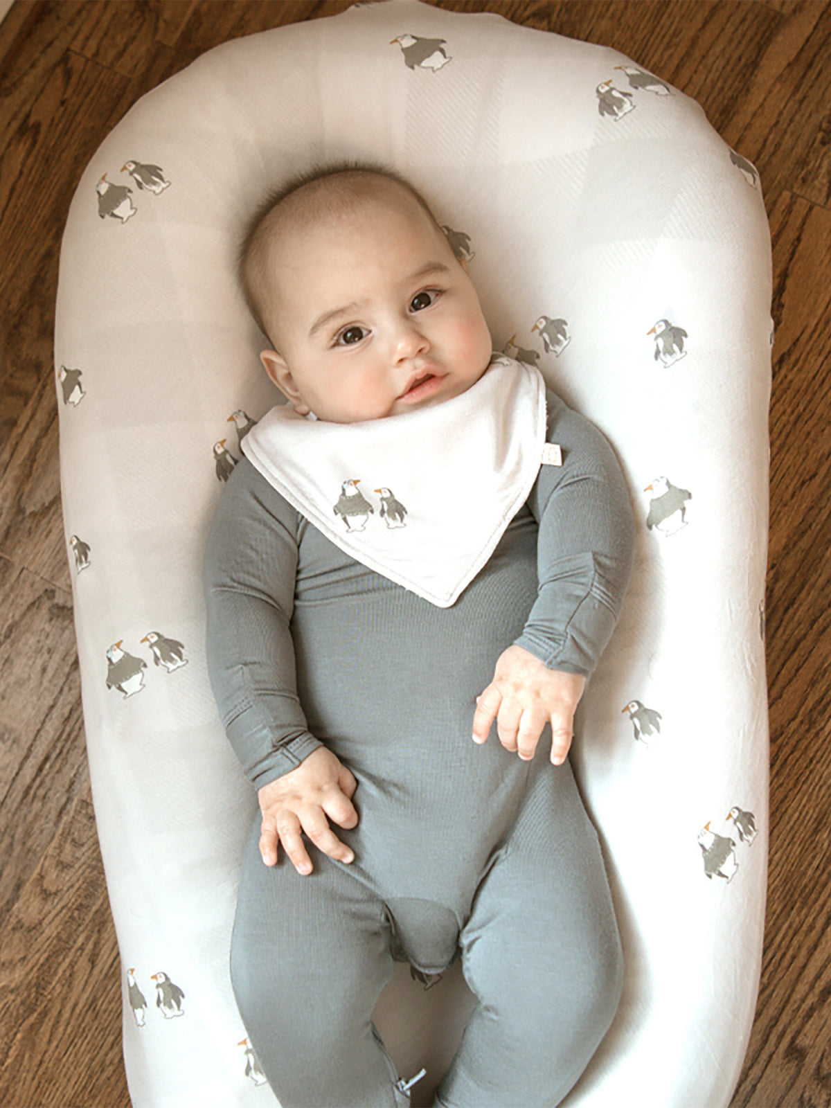 Light fabric changing pad cover, curved oval shape, gray penguin pattern