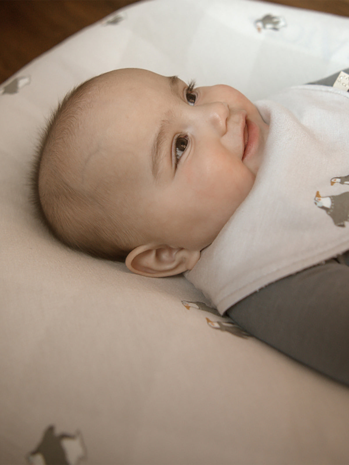 Light changing pad cover with small gray penguin pattern and folded edges
