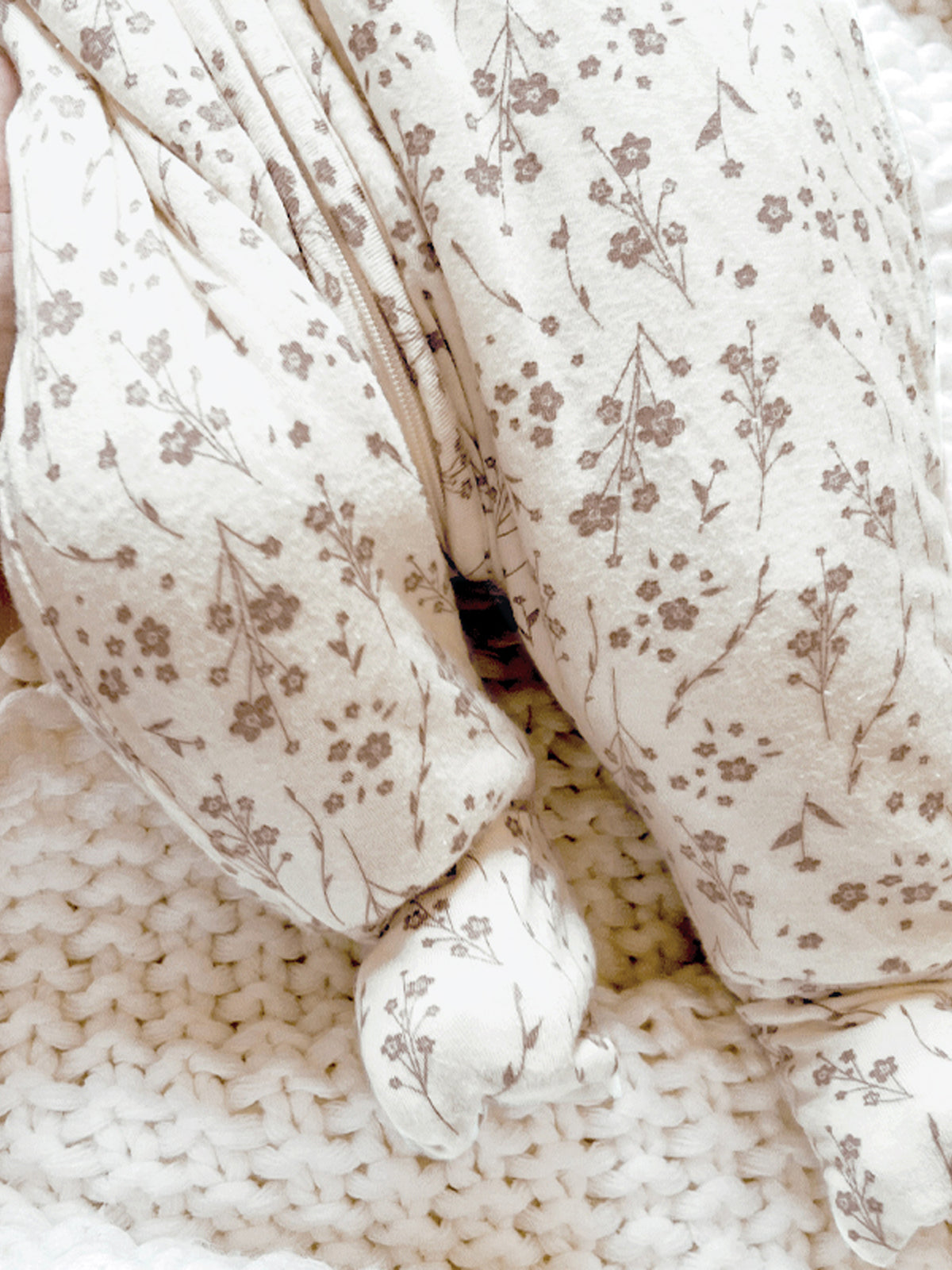 Footed sleep sack with cream floral print and enclosed feet, cuffed ankles