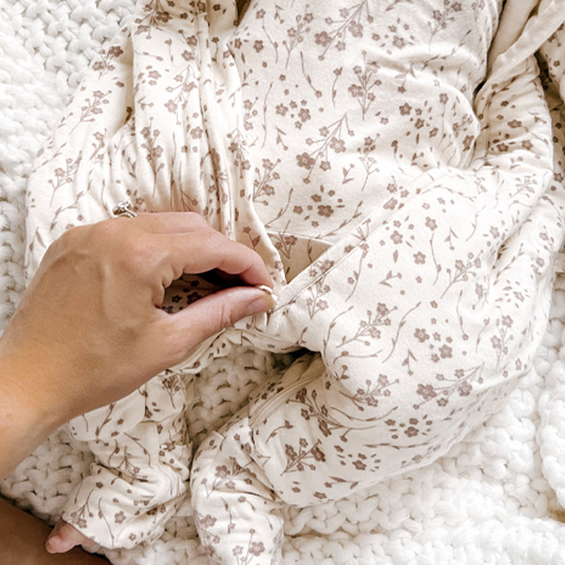 Baby footed sleep sack in cream with small brown floral pattern and cuffed legs