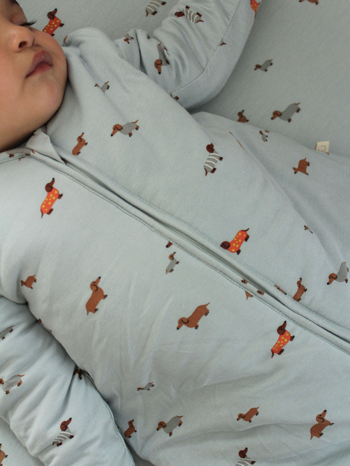 Light blue sleep sack with colorful dachshund print, zip seam detail