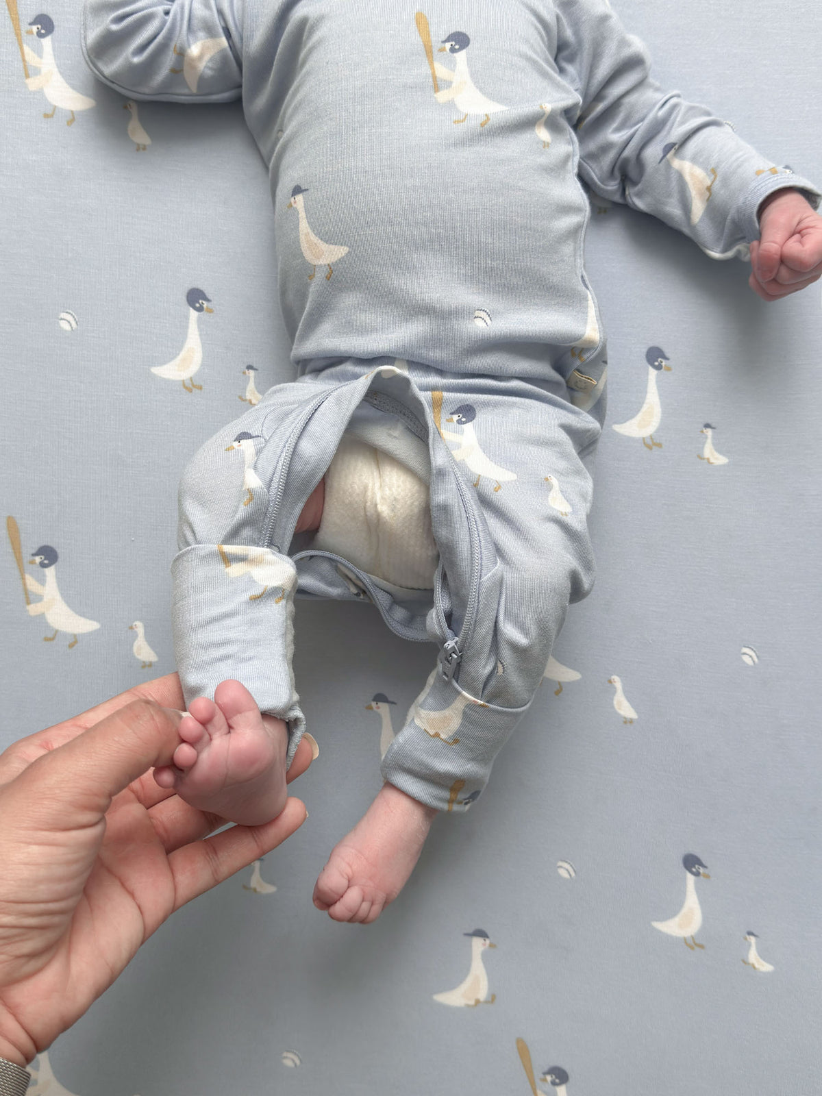 Light blue goose-print convertible baby pajama with leg opening and buttoned front