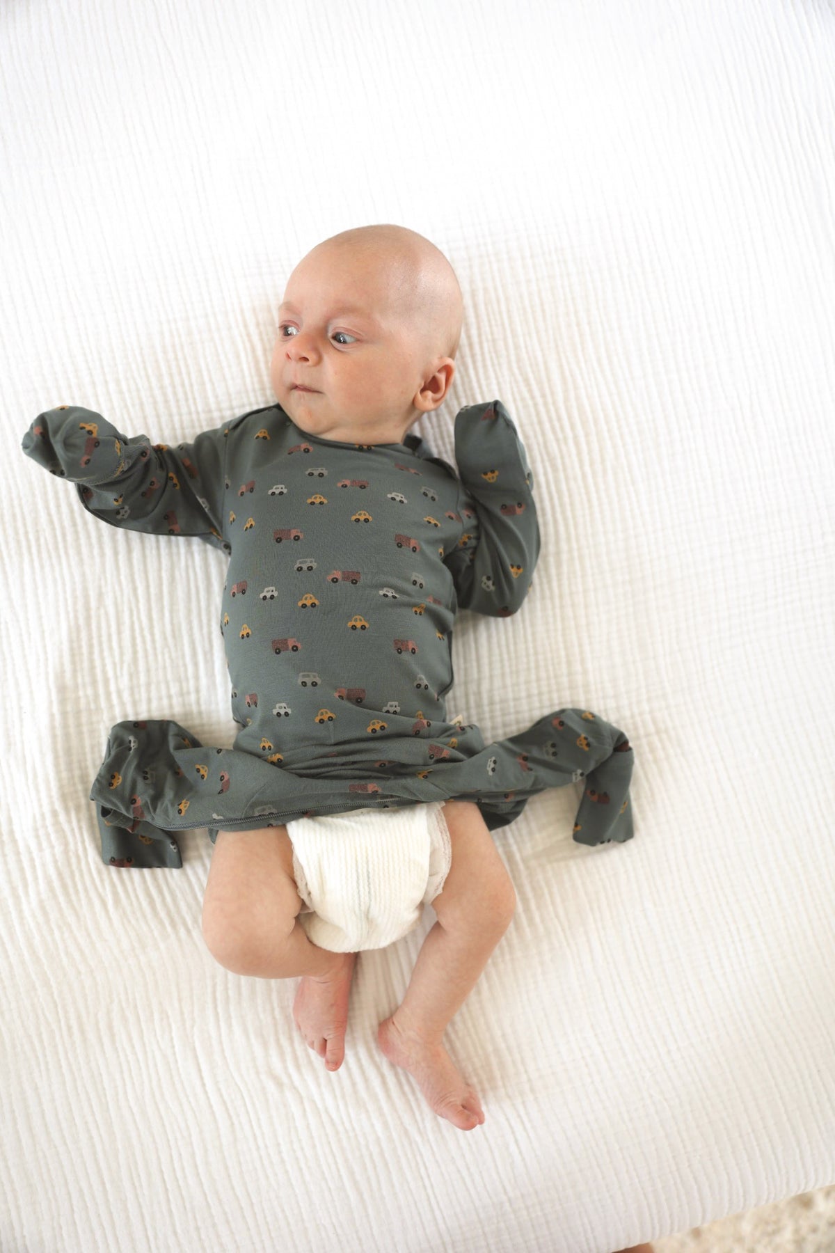 Dark gray printed baby pajamas with long sleeves and footed legs, front view