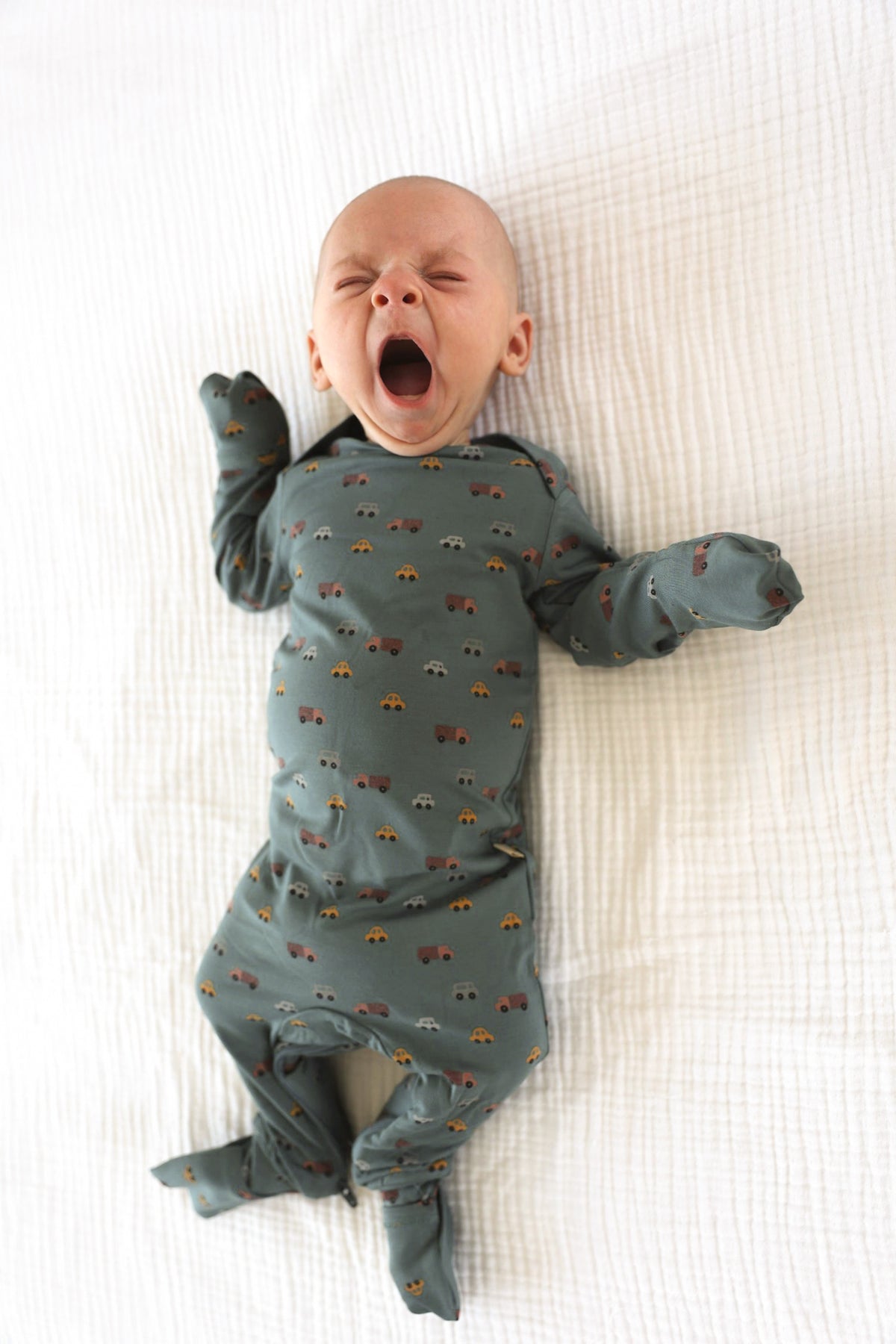 Dark gray printed baby pajamas with long sleeves and footed legs, full-body view