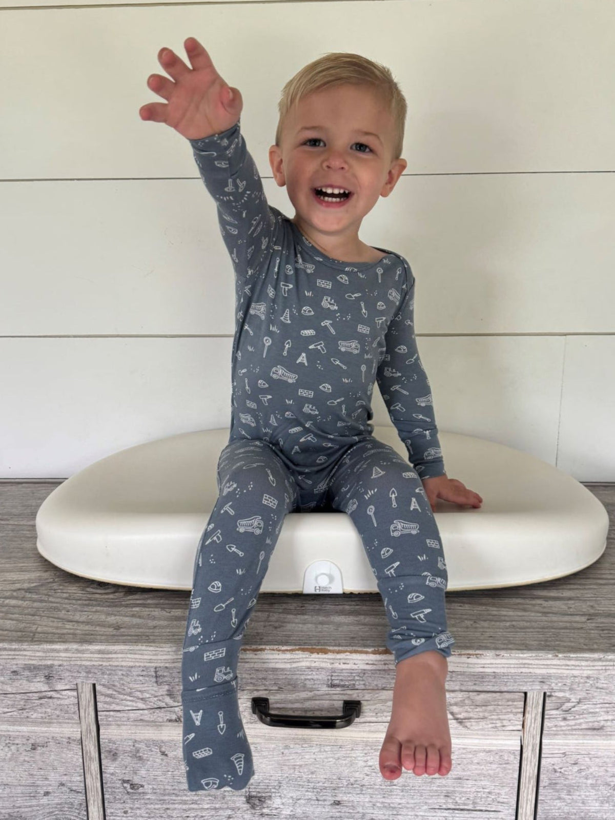 Blue construction-print convertible pajamas on a standing child