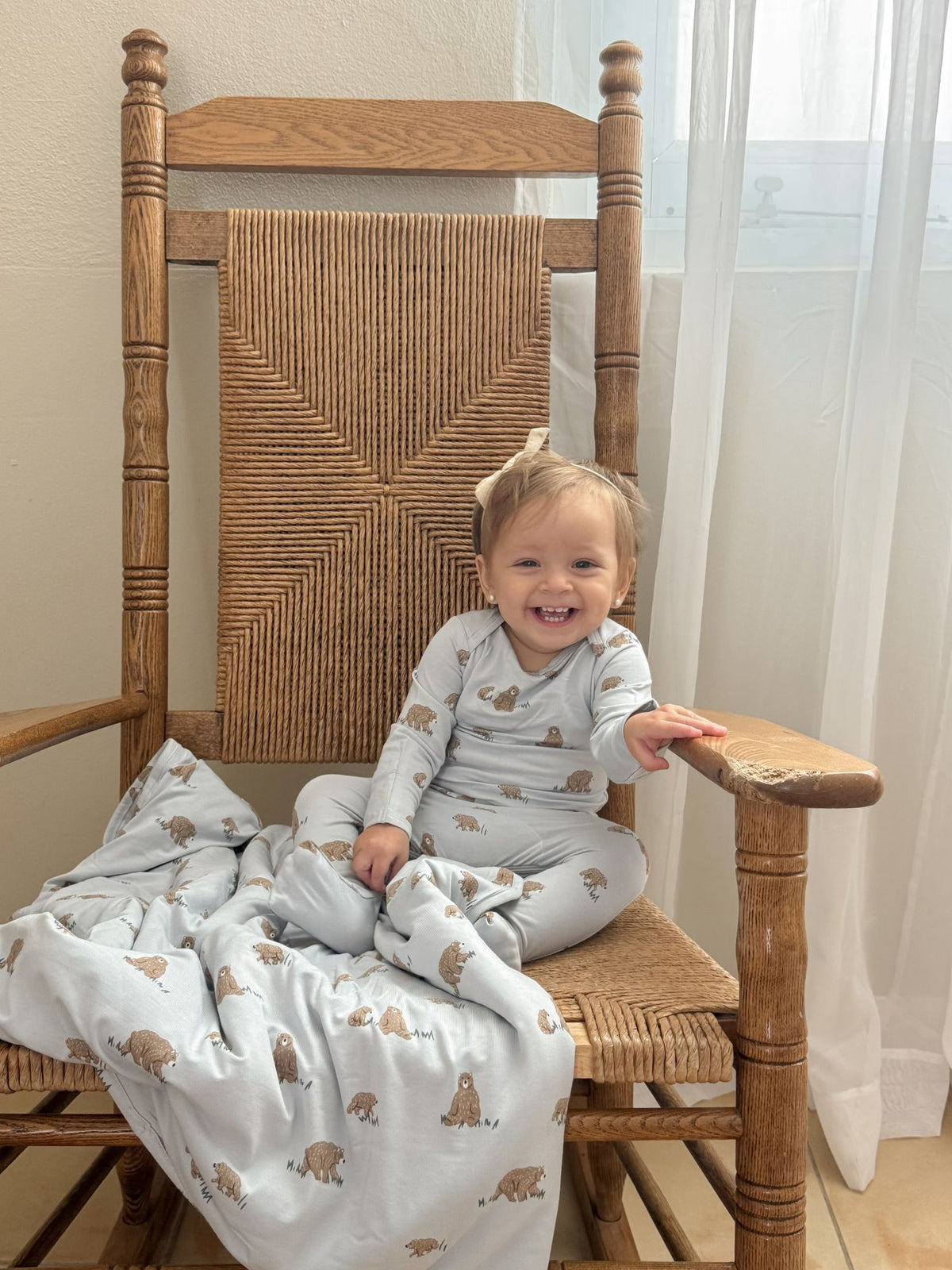 Teddy-printed convertible pajama, baby sitting in a one-piece with foot covers