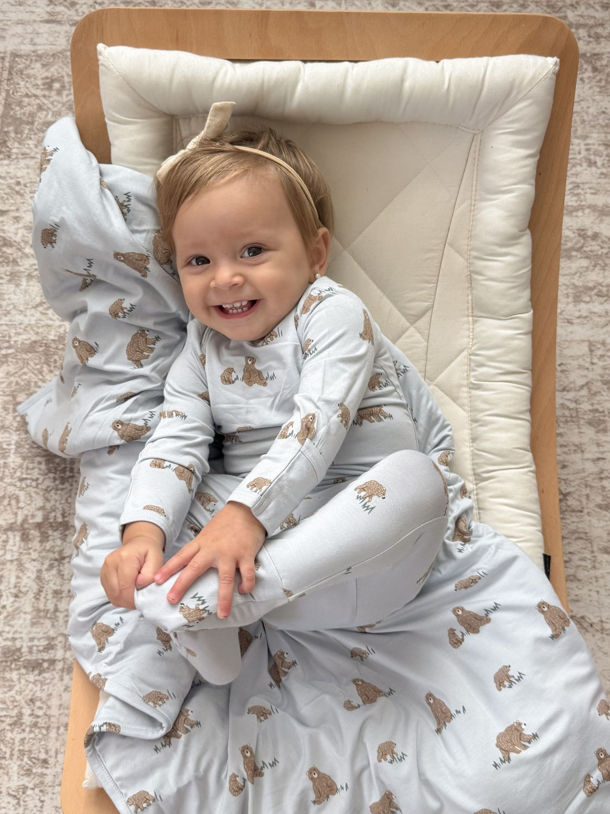 Smiling baby in teddy-printed convertible pajama with long sleeves and foot covers