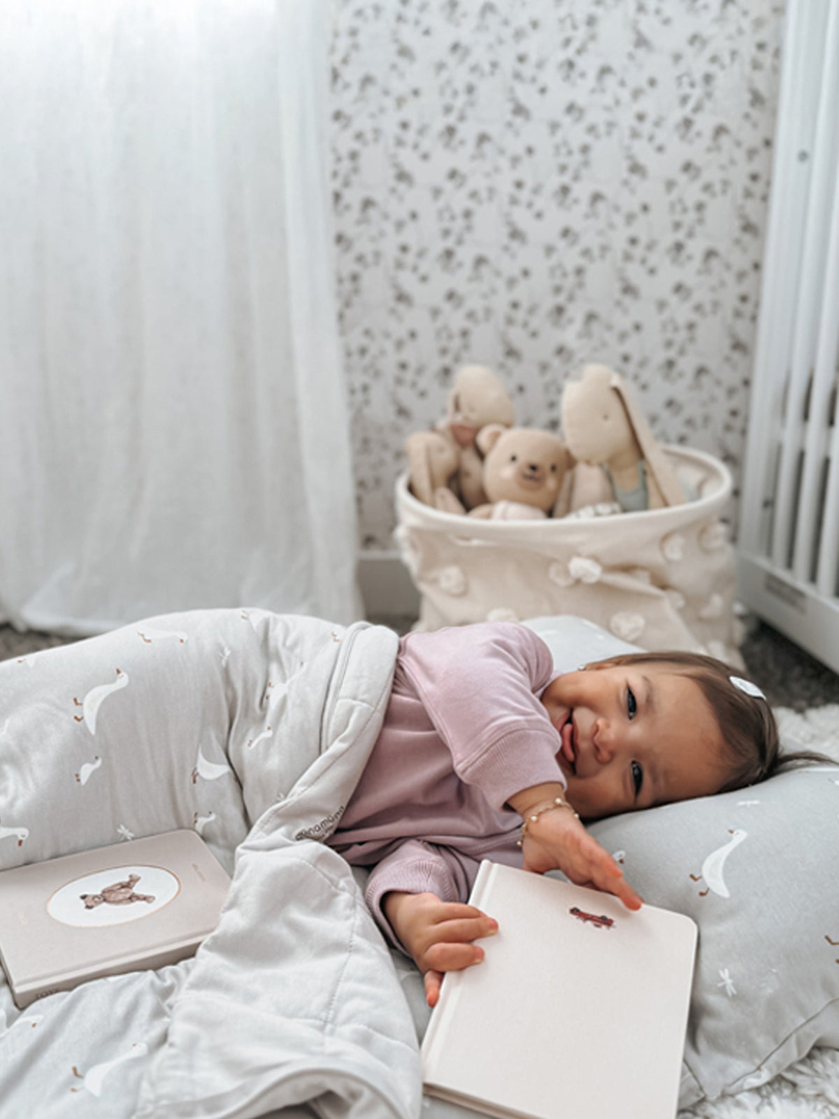 Goose-pattern nap mat with baby lying down, white geese print on light gray fabric
