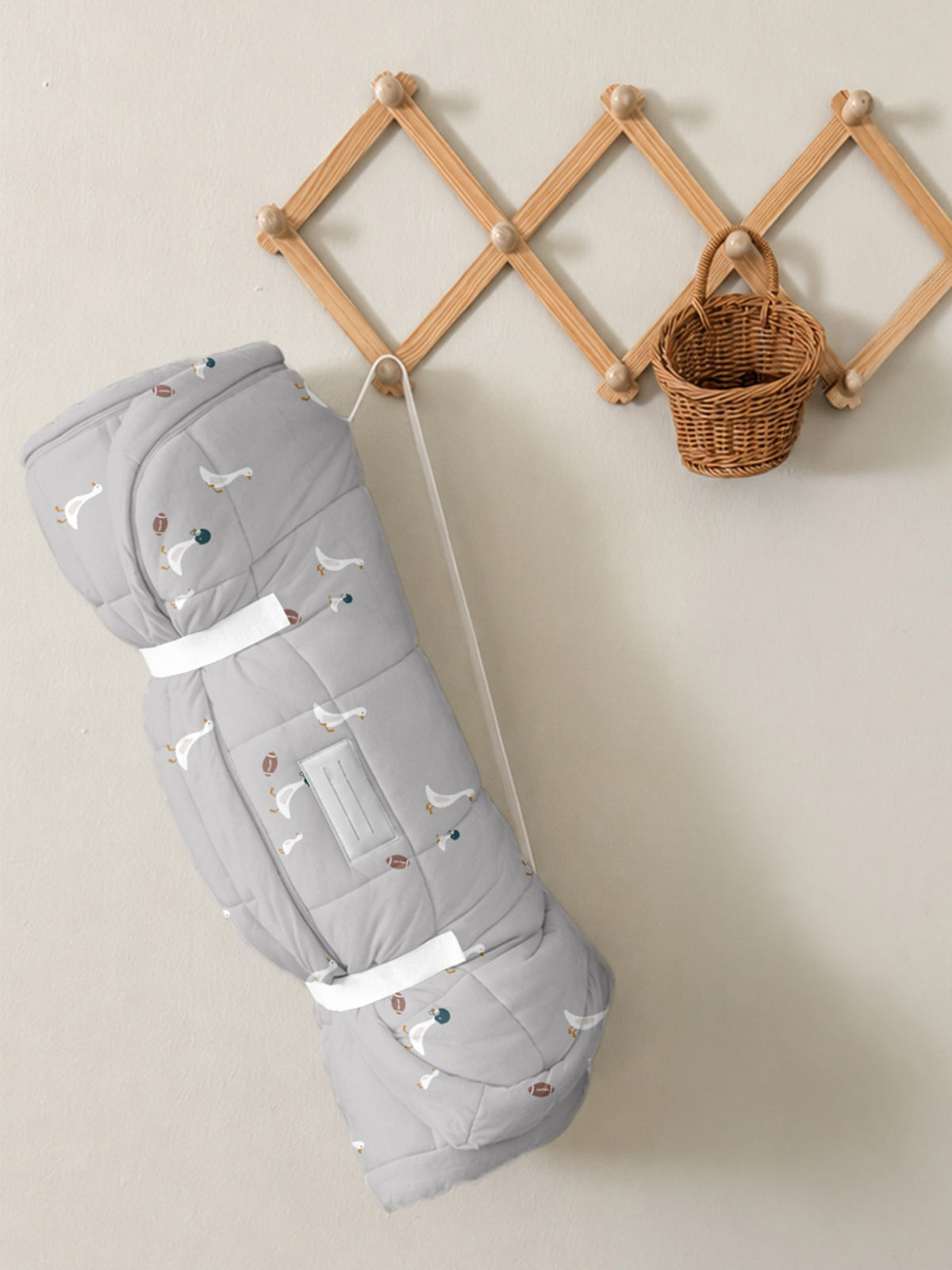 Gray quilted baby nap mat with goose and football prints, folded with carry strap