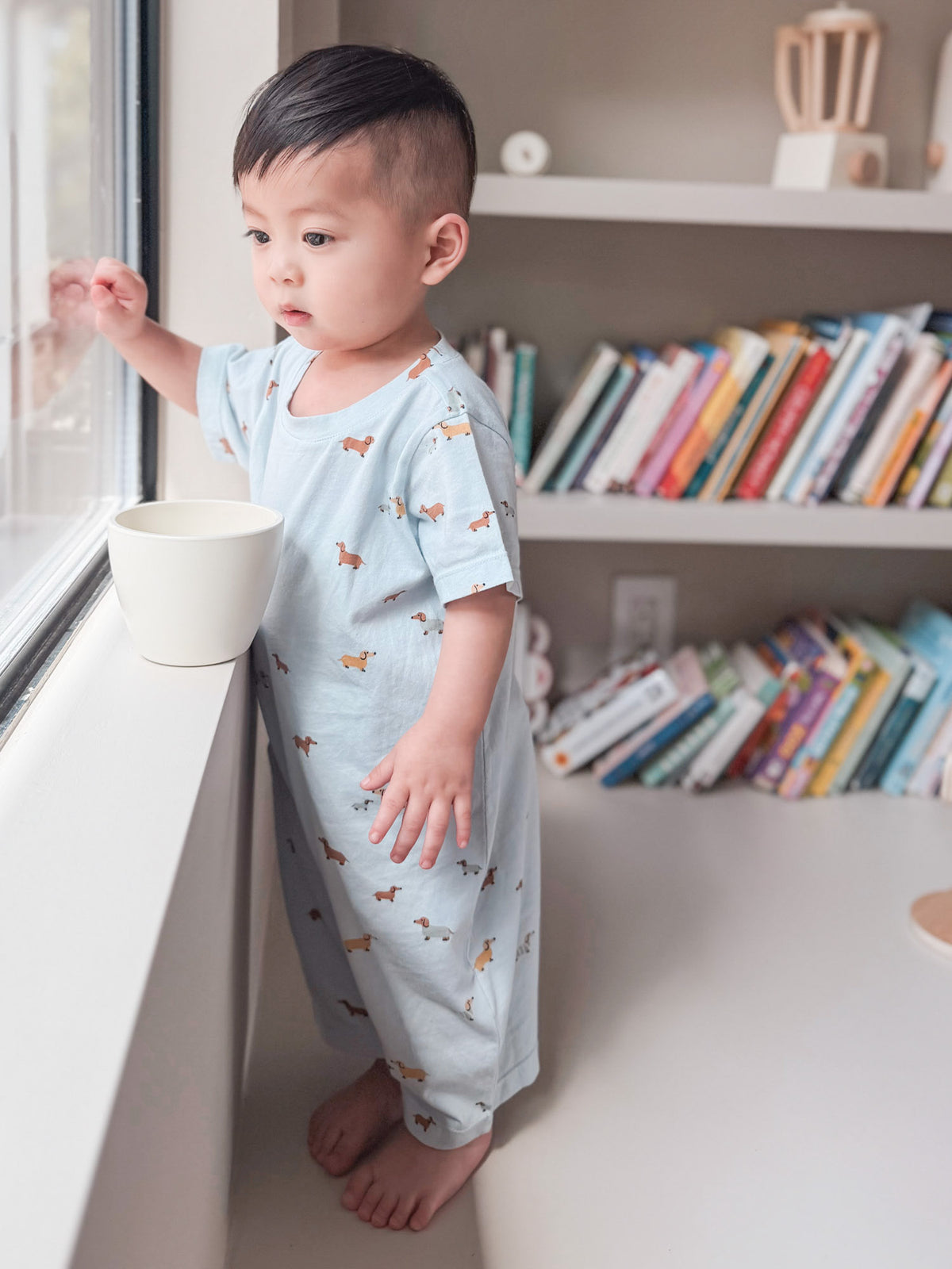 Woof cotton shortie romper in light blue, all-over dog print, short sleeves