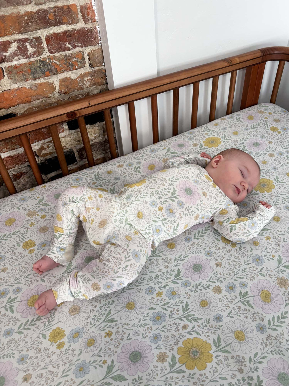 Wildflower-print convertible pajama footed onesie with long sleeves, laid out