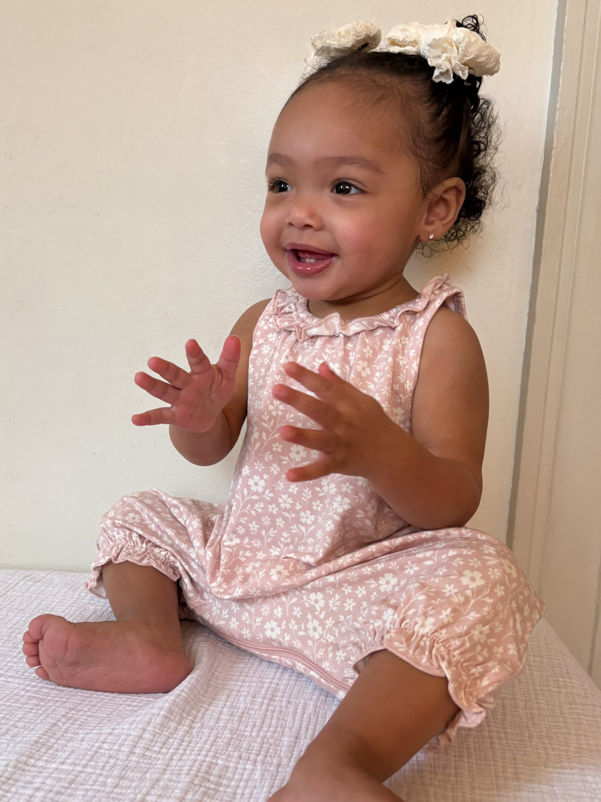 Light pink floral sleeveless bubble romper with ruffled neckline and gathered sleeves