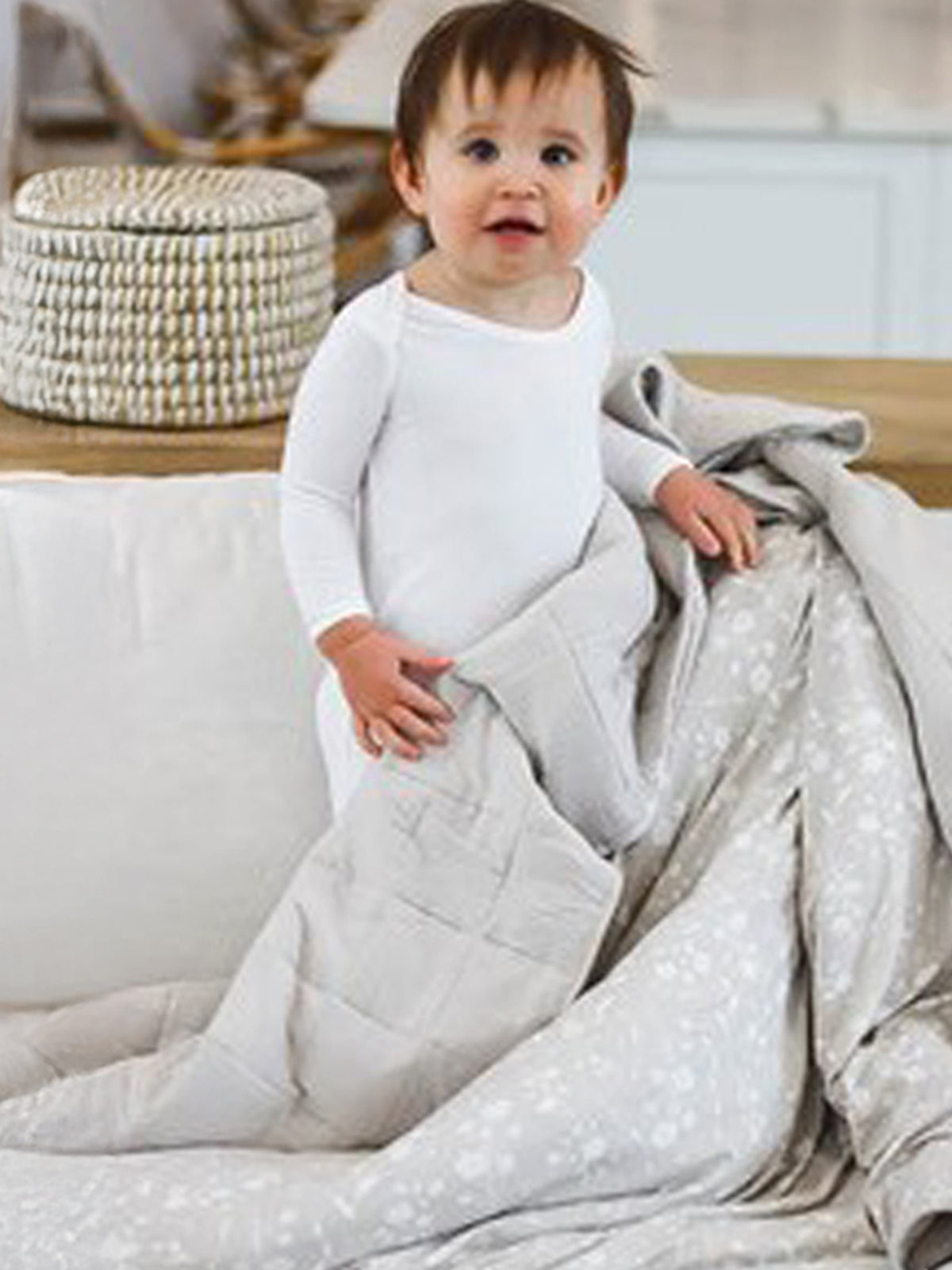 Light gray quilted baby blanket with cloud-style stitching and subtle speckle pattern