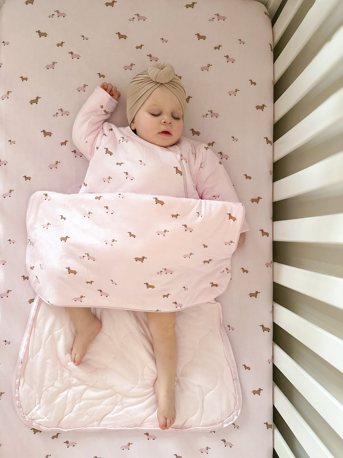 Pink long-sleeve sleep sack with allover dog print, wraparound wearable blanket