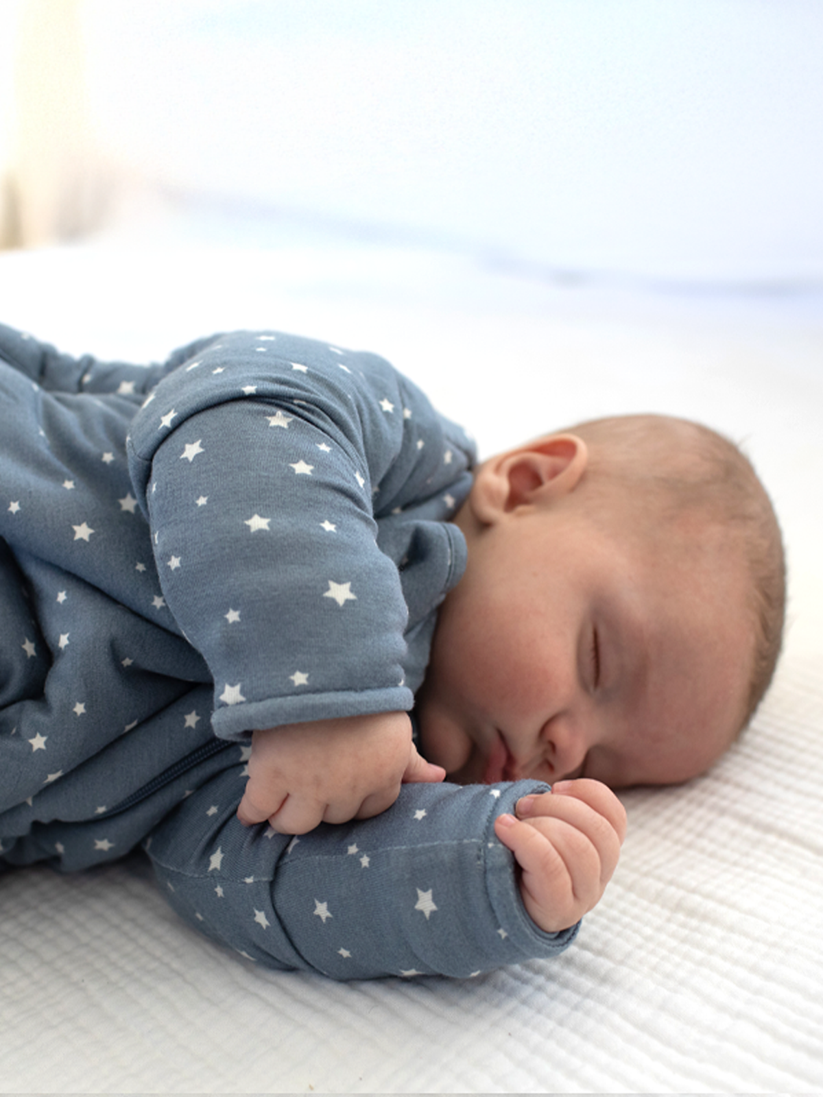 Gray star-print long sleeve sleep sack with covered hands, baby asleep