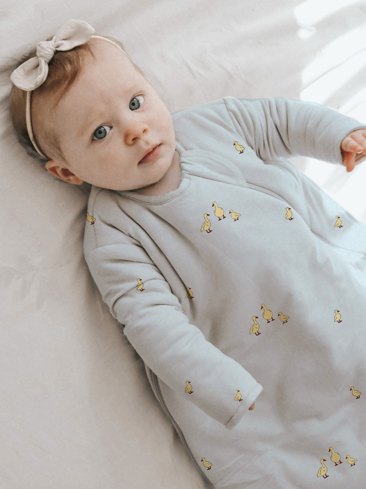 Long-sleeve sleep sack in light gray with small yellow character pattern