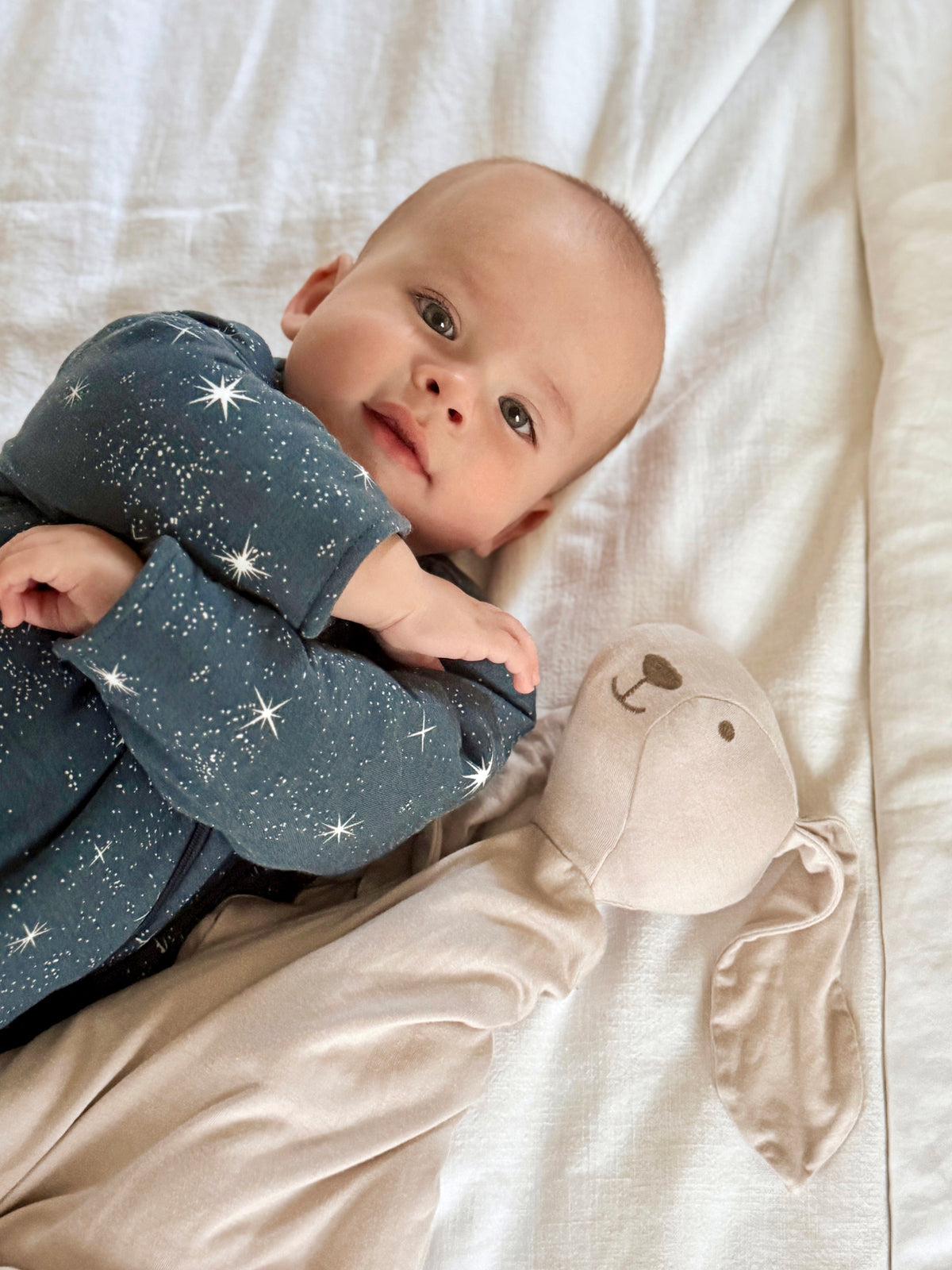 Long-sleeve sleep sack in dark blue with white star pattern and long, covered sleeves