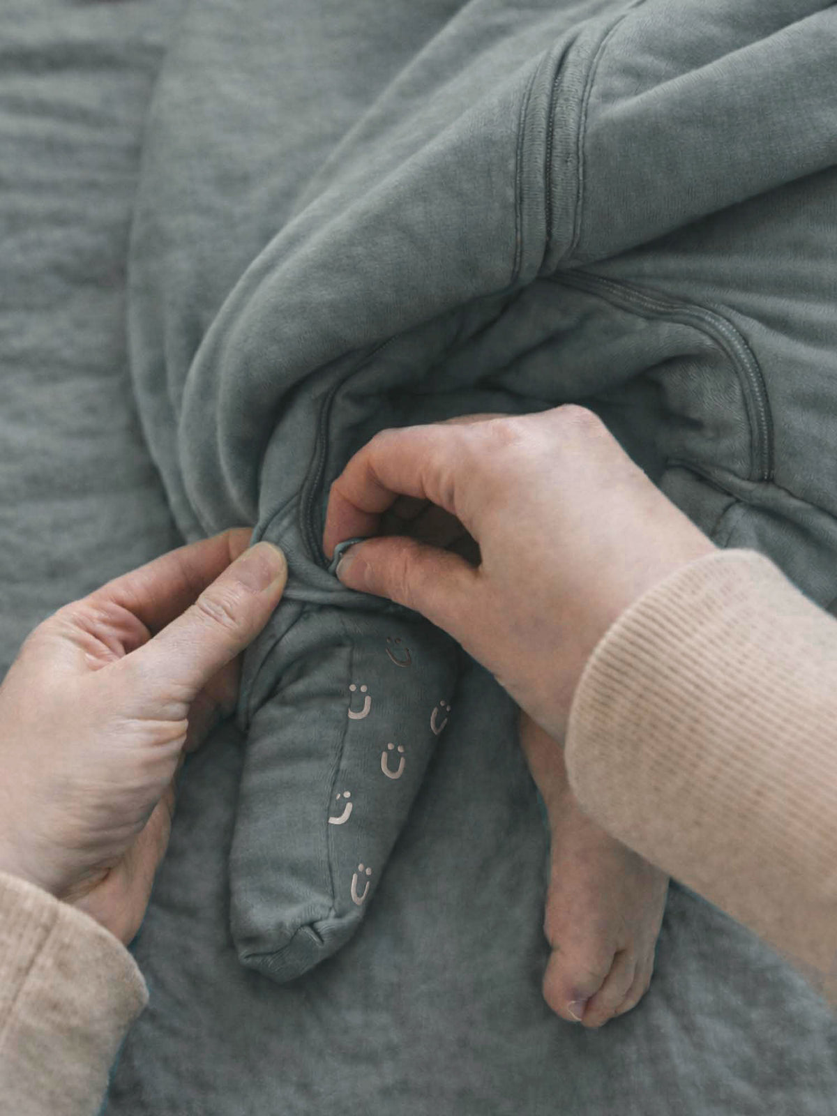 Gray footed sleep sack close-up of zipper area and stitched foot details