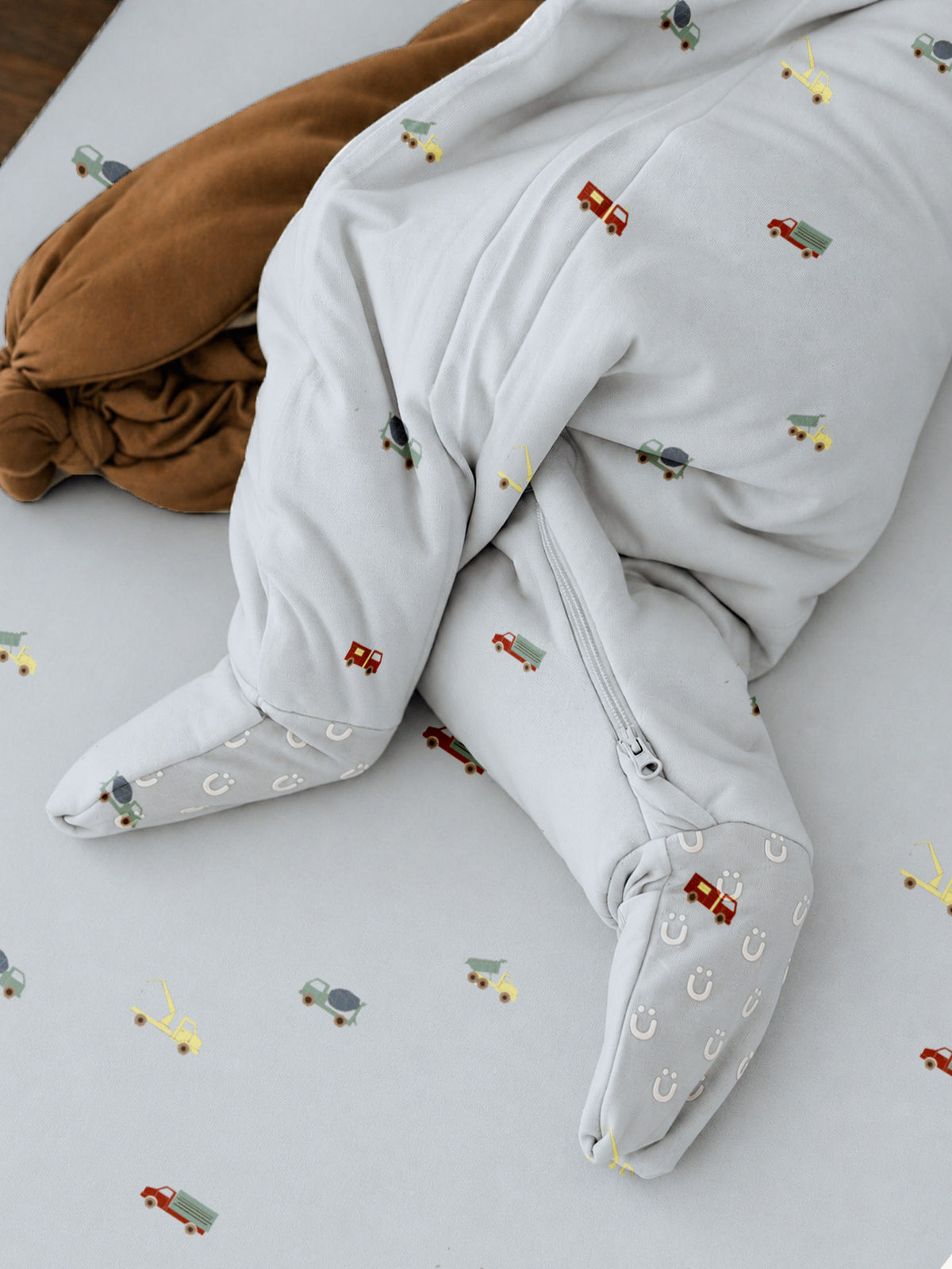 Light blue footie sleep sack with vehicle print and zipper closure, long sleeves