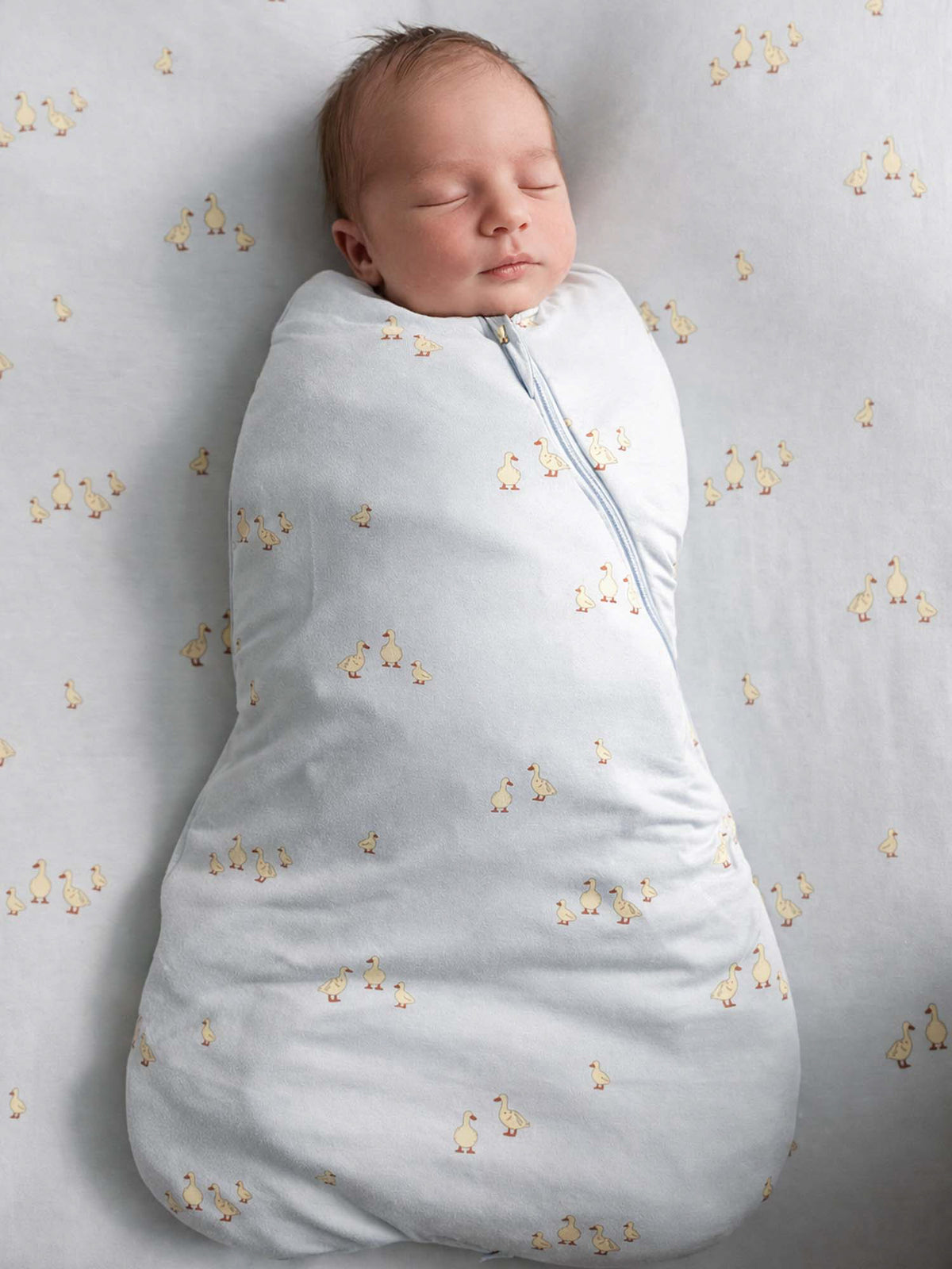 0.5 TOG swaddle sleep sack in light gray with small duck print, full-body wrap
