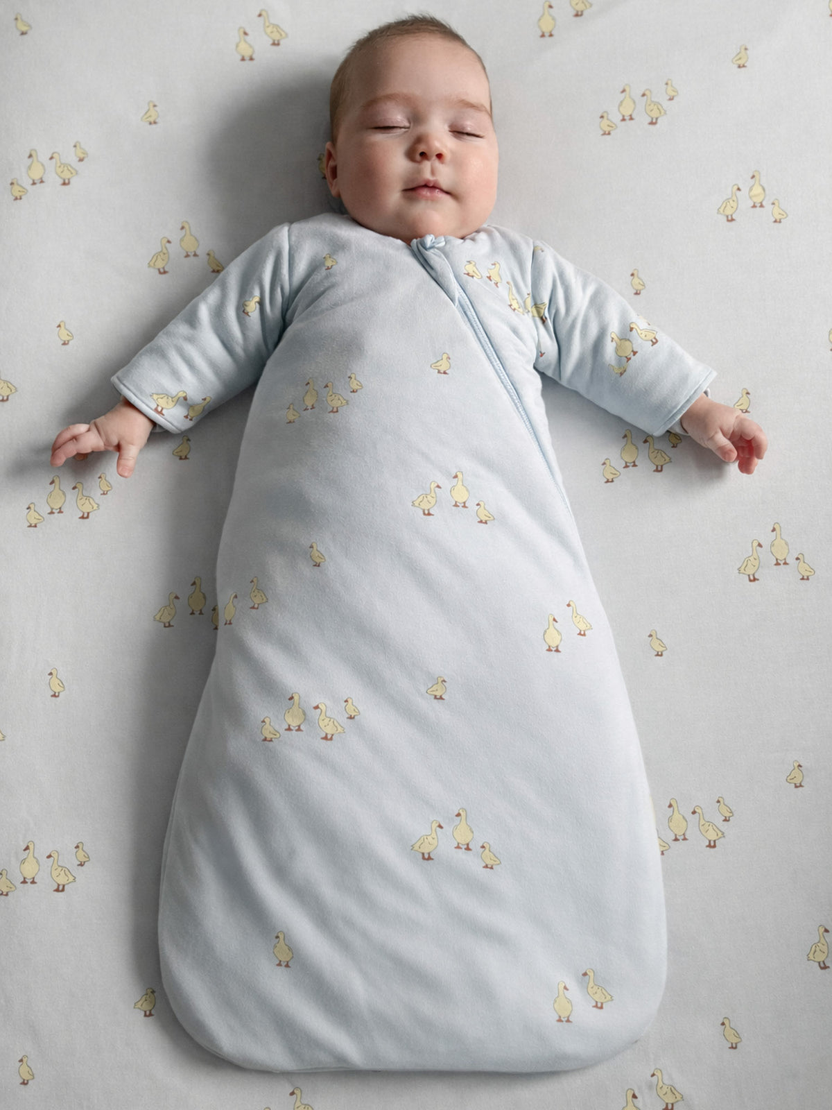 Light gray swaddle sleep sack, long sleeves, yellow animal print, front zipper