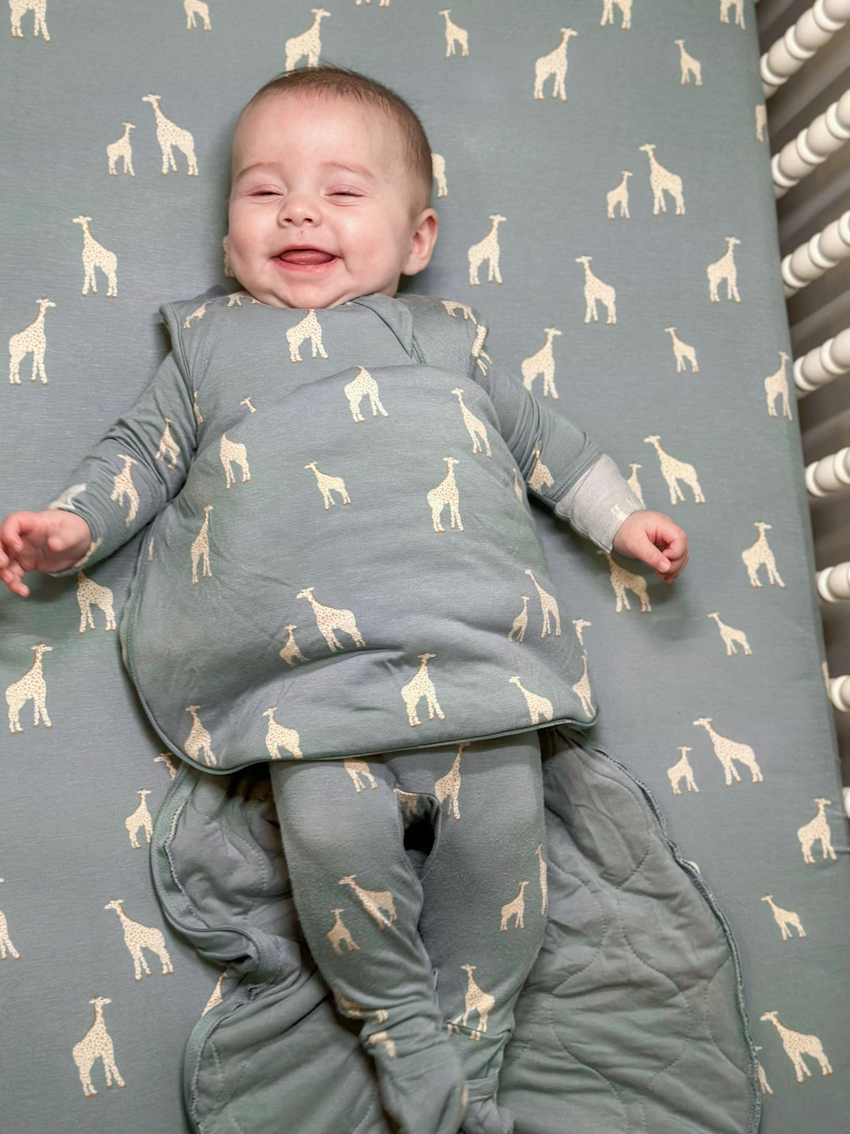 Moss green swaddle sleep sack with giraffe print, zip front, padded wrap style