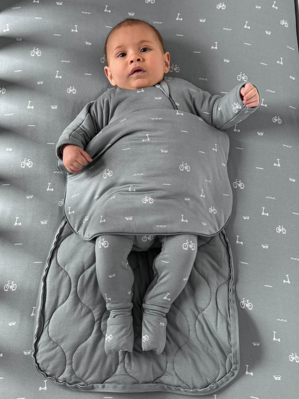 Gray long-sleeve swaddle sack with zipper and allover bike/letter pattern, padded