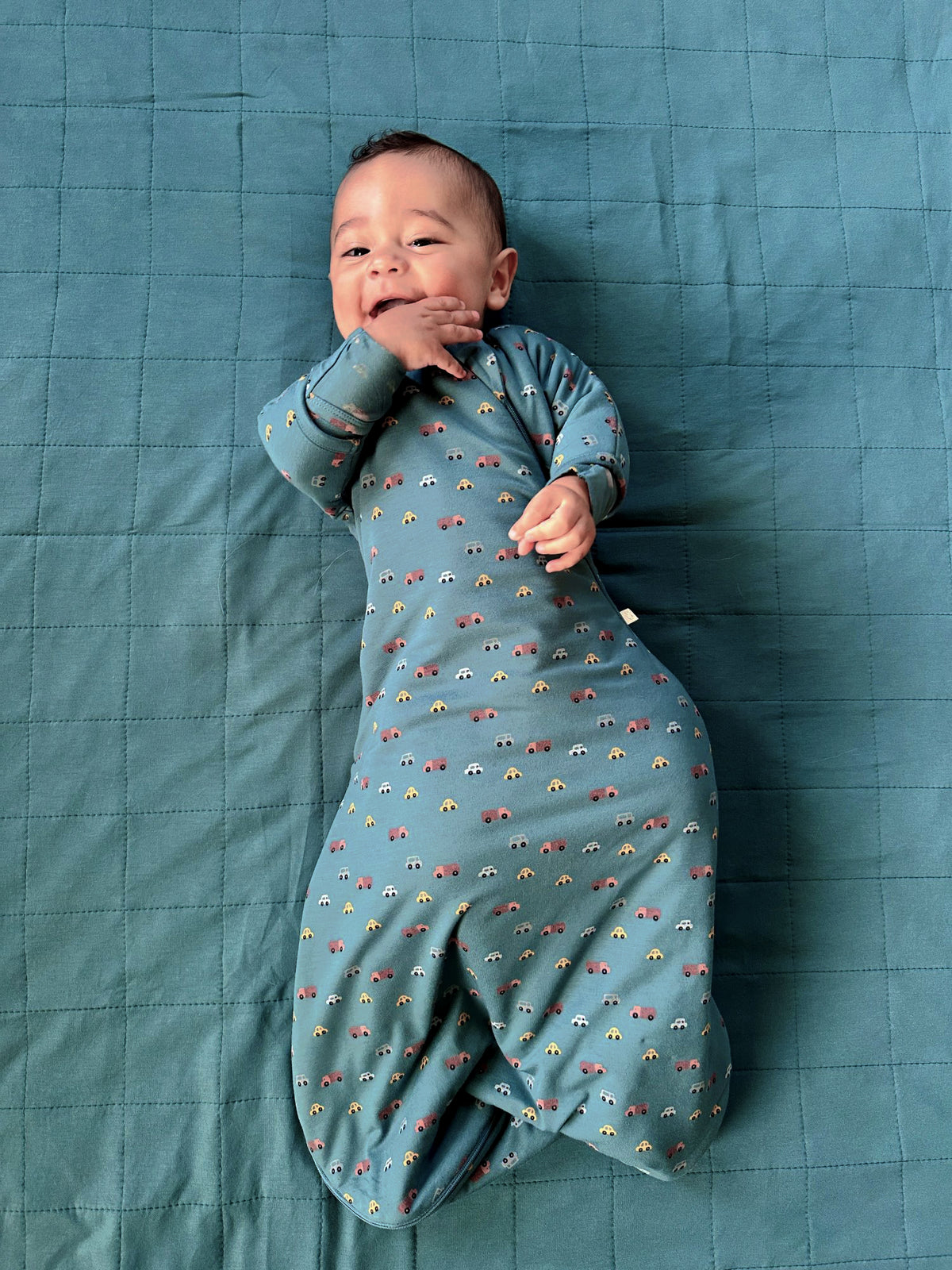 Teal long-sleeve swaddle sack with multicolor vehicle print, open bottom