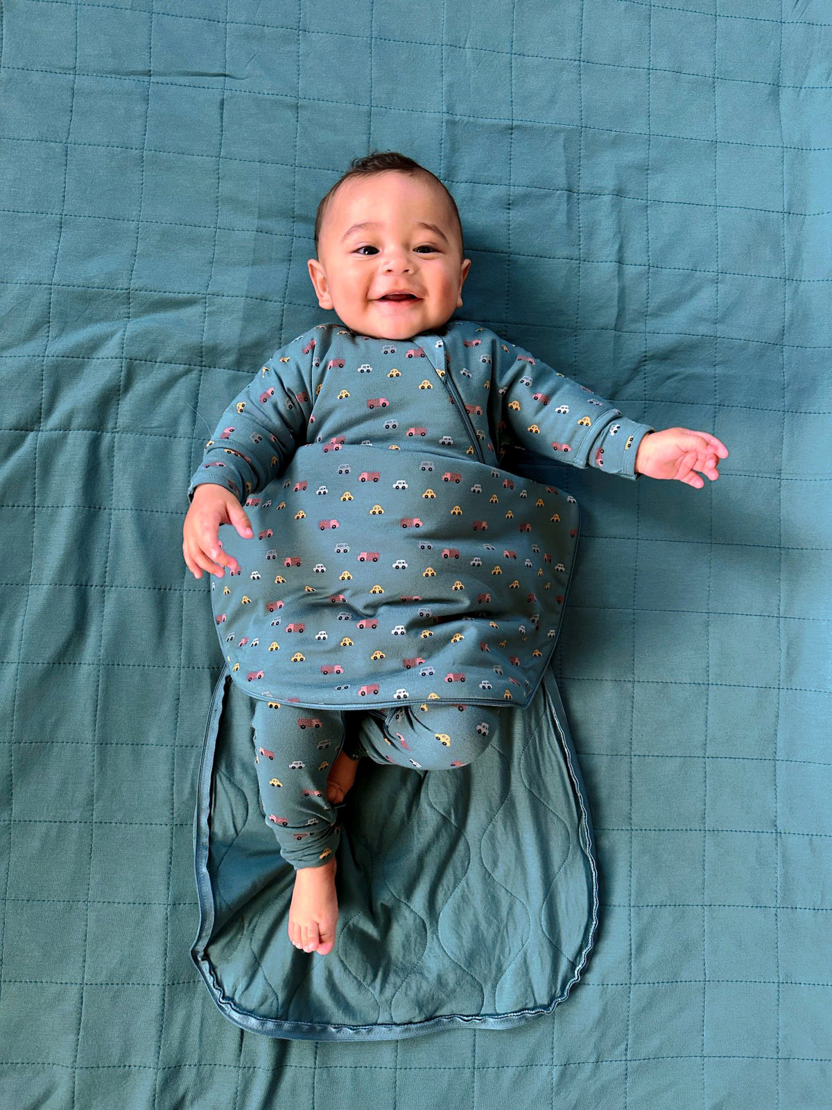 Teal long-sleeve swaddle sack with multicolor print, open bottom for baby