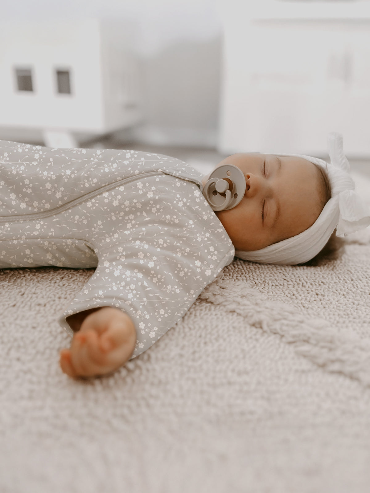 Long sleeve swaddle sack in beige with white floral pattern, long sleeves and zipper