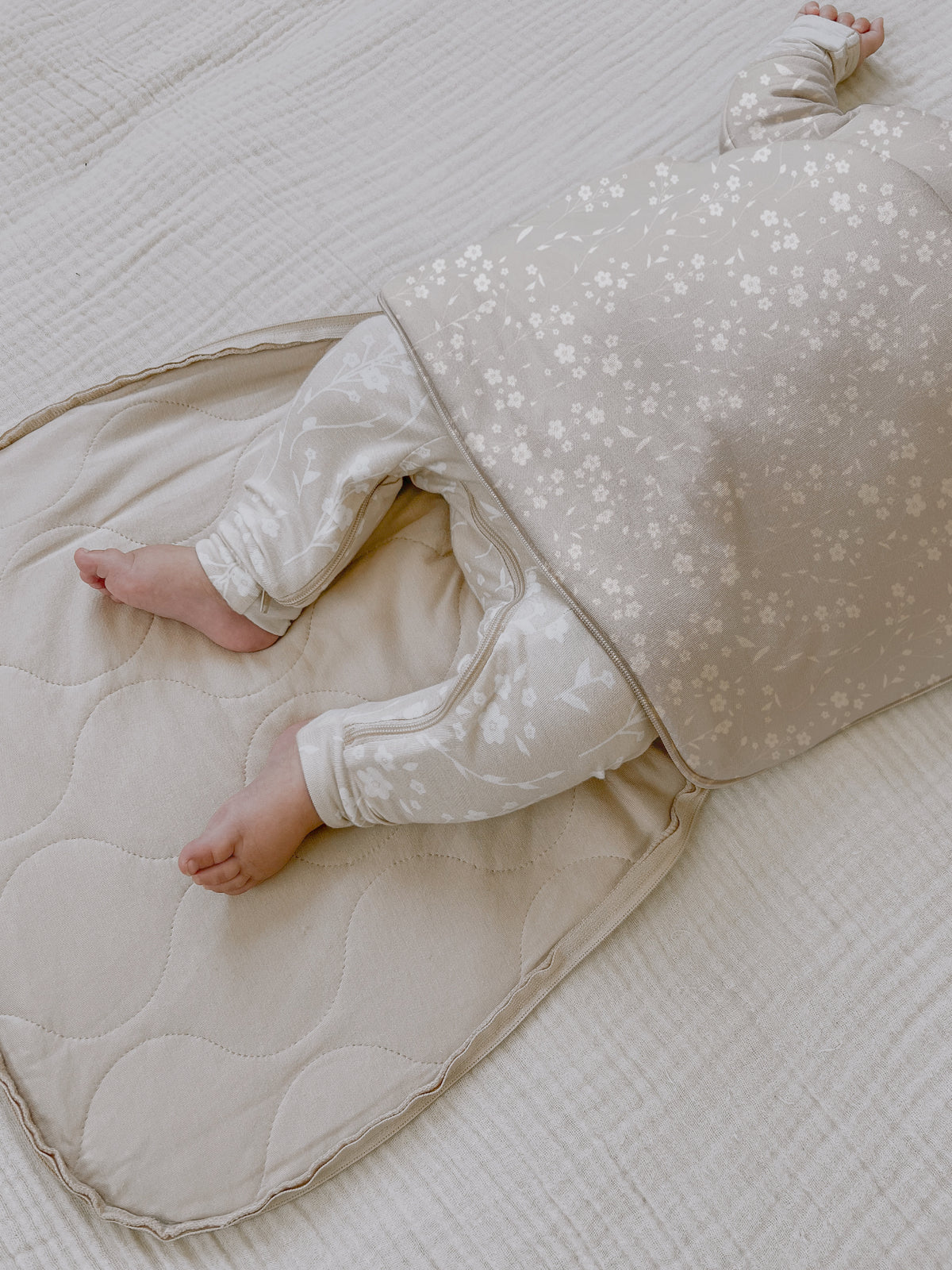 Long sleeve swaddle sack in beige with white floral print, open front panel detail
