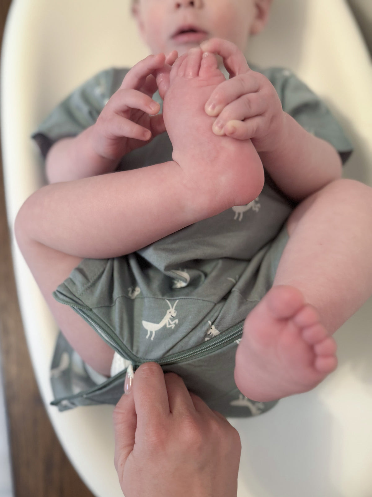 Sage green cotton short romper with white animal prints, short sleeves and legs