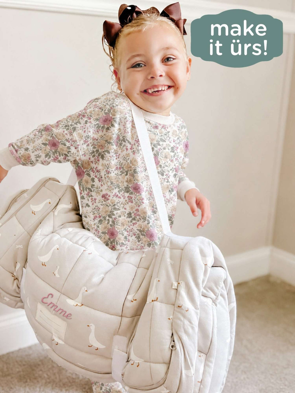 Goose-pattern nap mat carrier with strap, baby smiling; white geese print on light gray