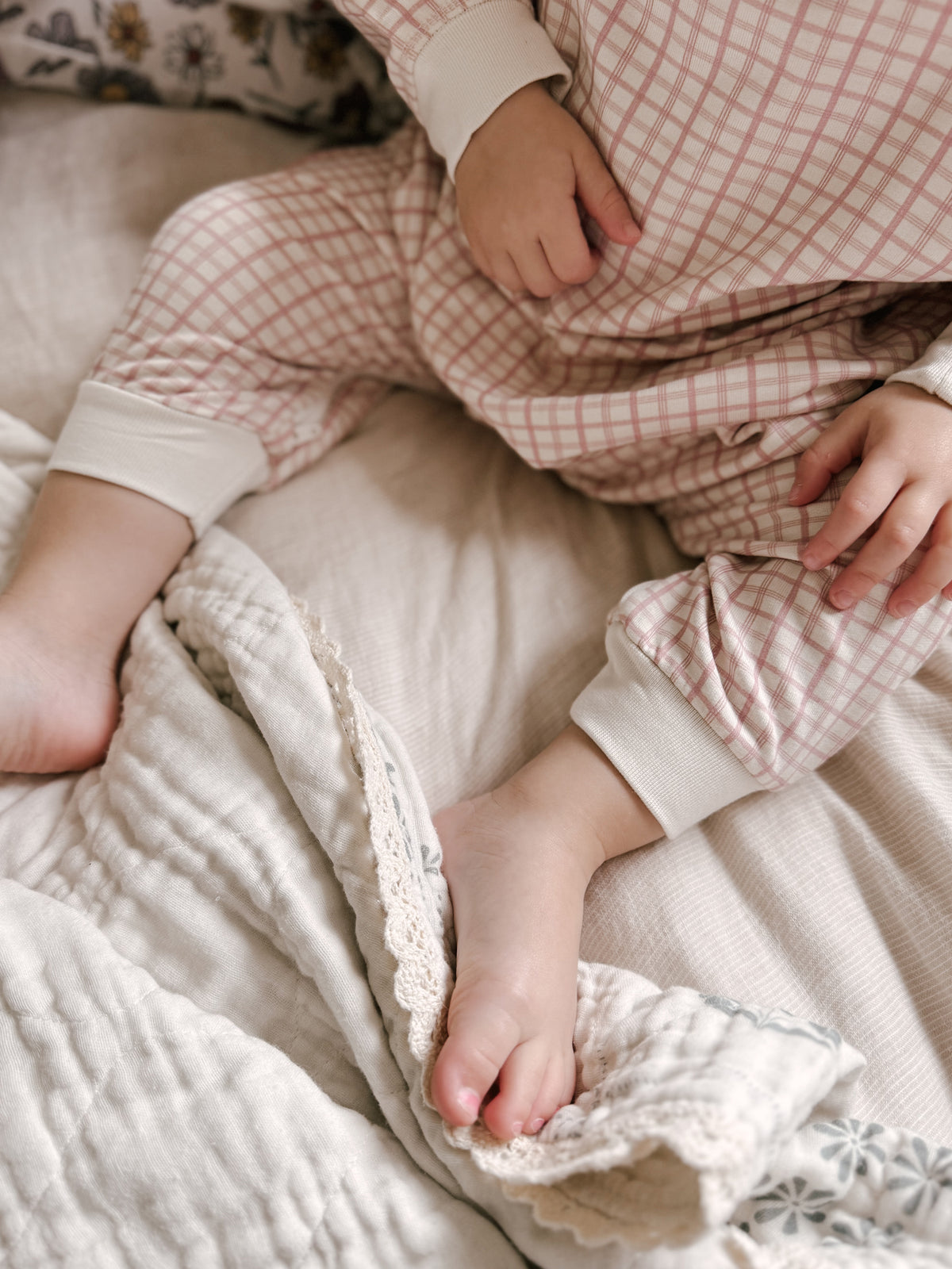 Light pink fleece jumpsuit with white cuffs and ruffled leg openings, long sleeves