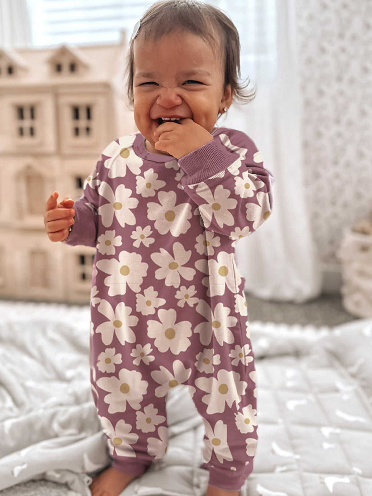 Purple fleece jumpsuit with white daisy print, long sleeves and footed legs