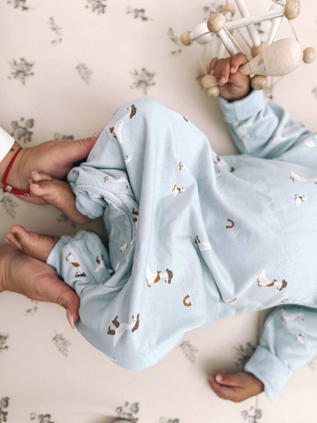 Light blue fleece jumpsuit with animal print, laid back with arms lifted