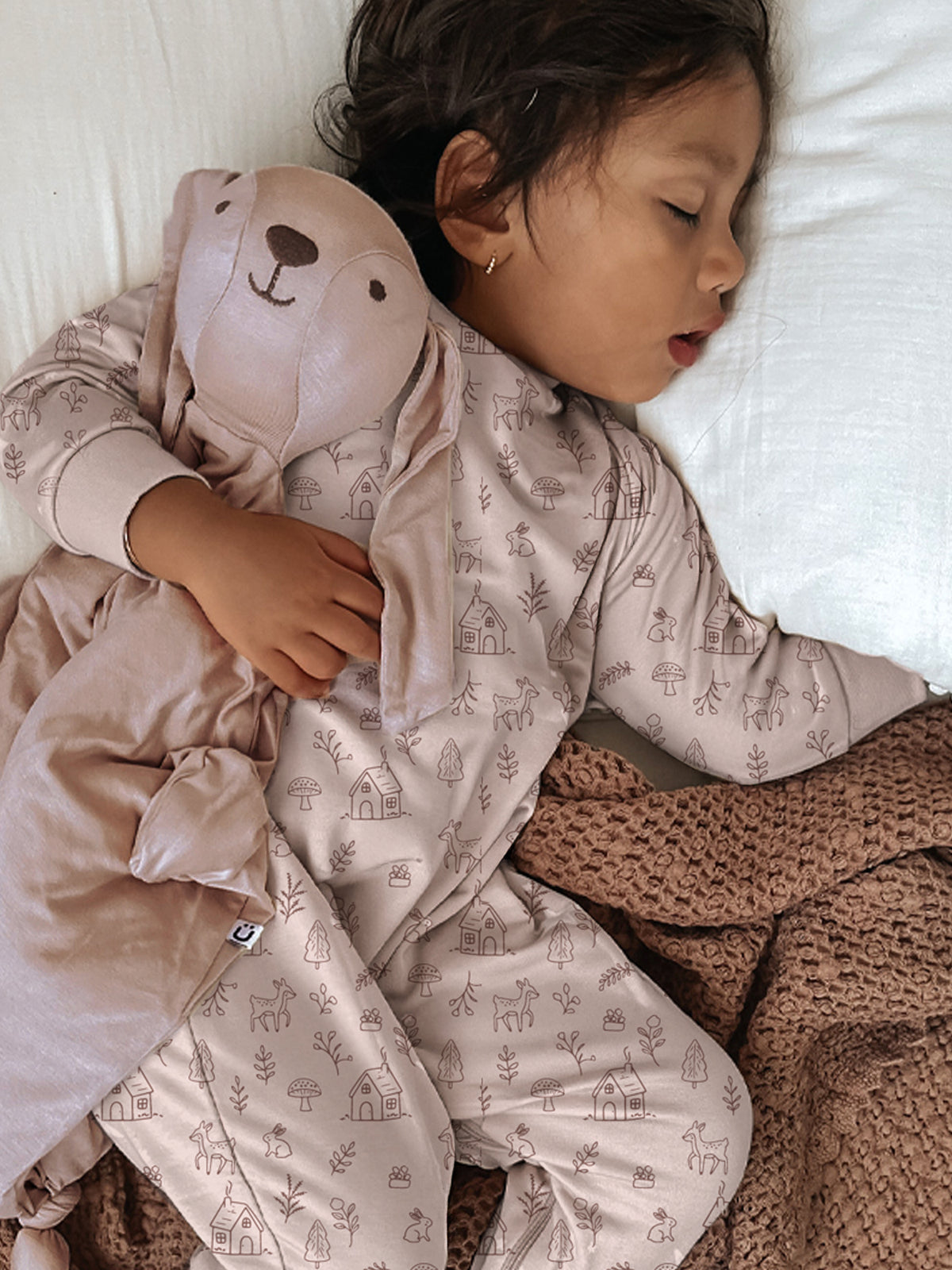 Light pink fleece jumpsuit with allover small animal print, buttoned legs