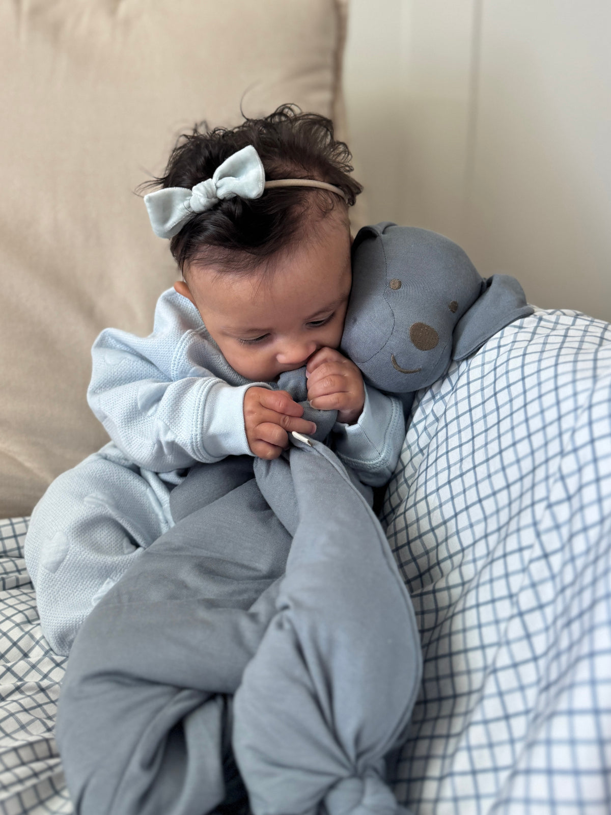 Light blue-gray baby jumpsuit with animal-shaped hood and soft footed legs
