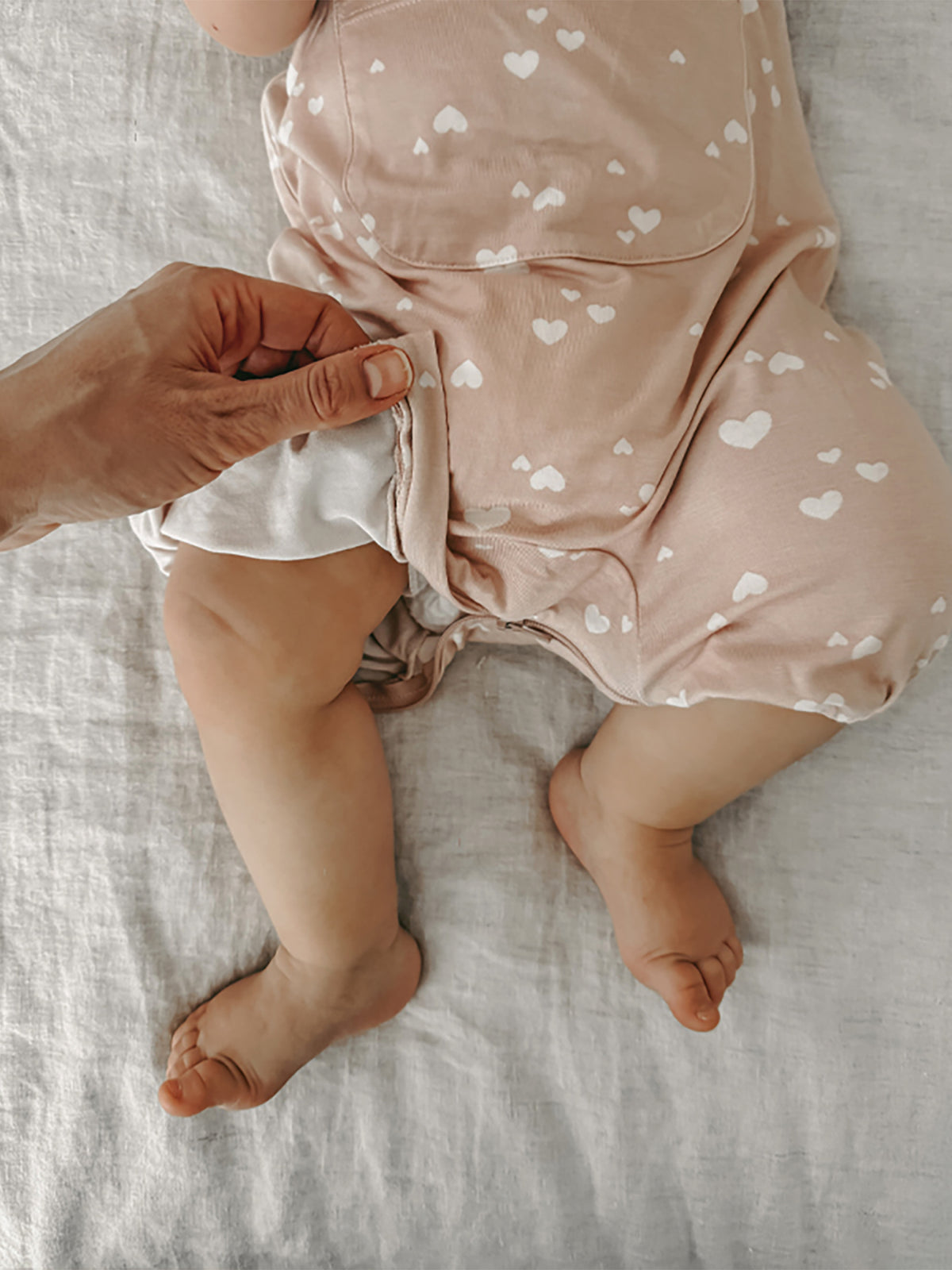 Heart print pink romper with front ruffle trim and elastic waist and leg openings